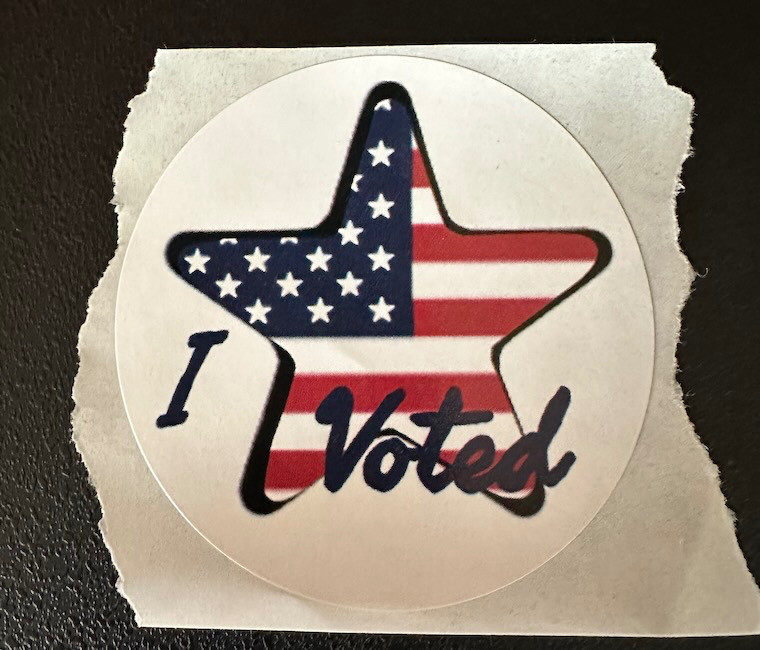 Sticker that says "I voted". The background is a star with the US flag inside of it