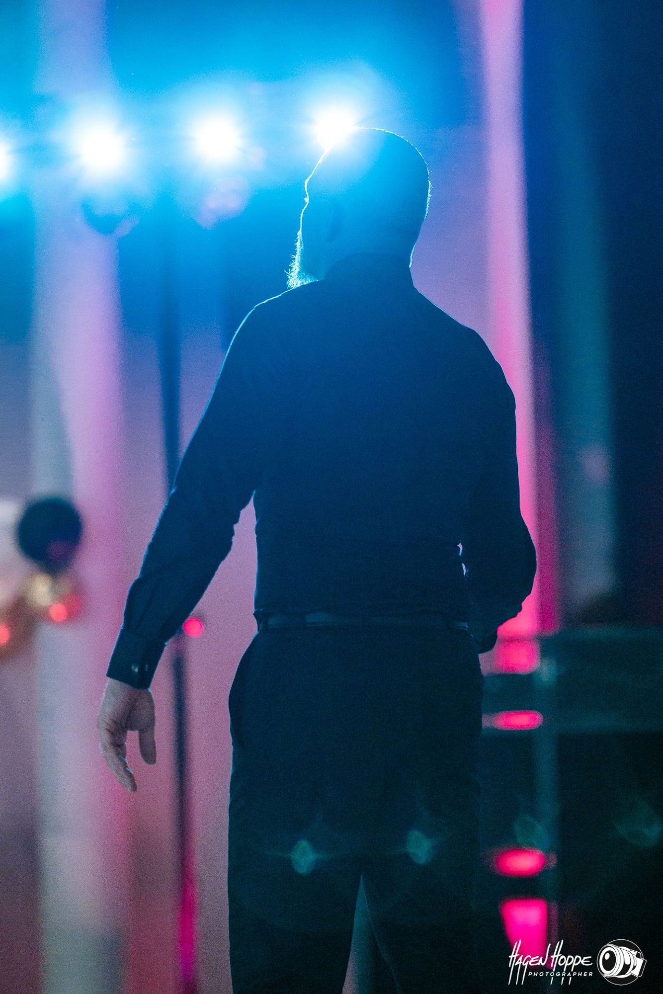 A man from the back in the disco light at a wedding party