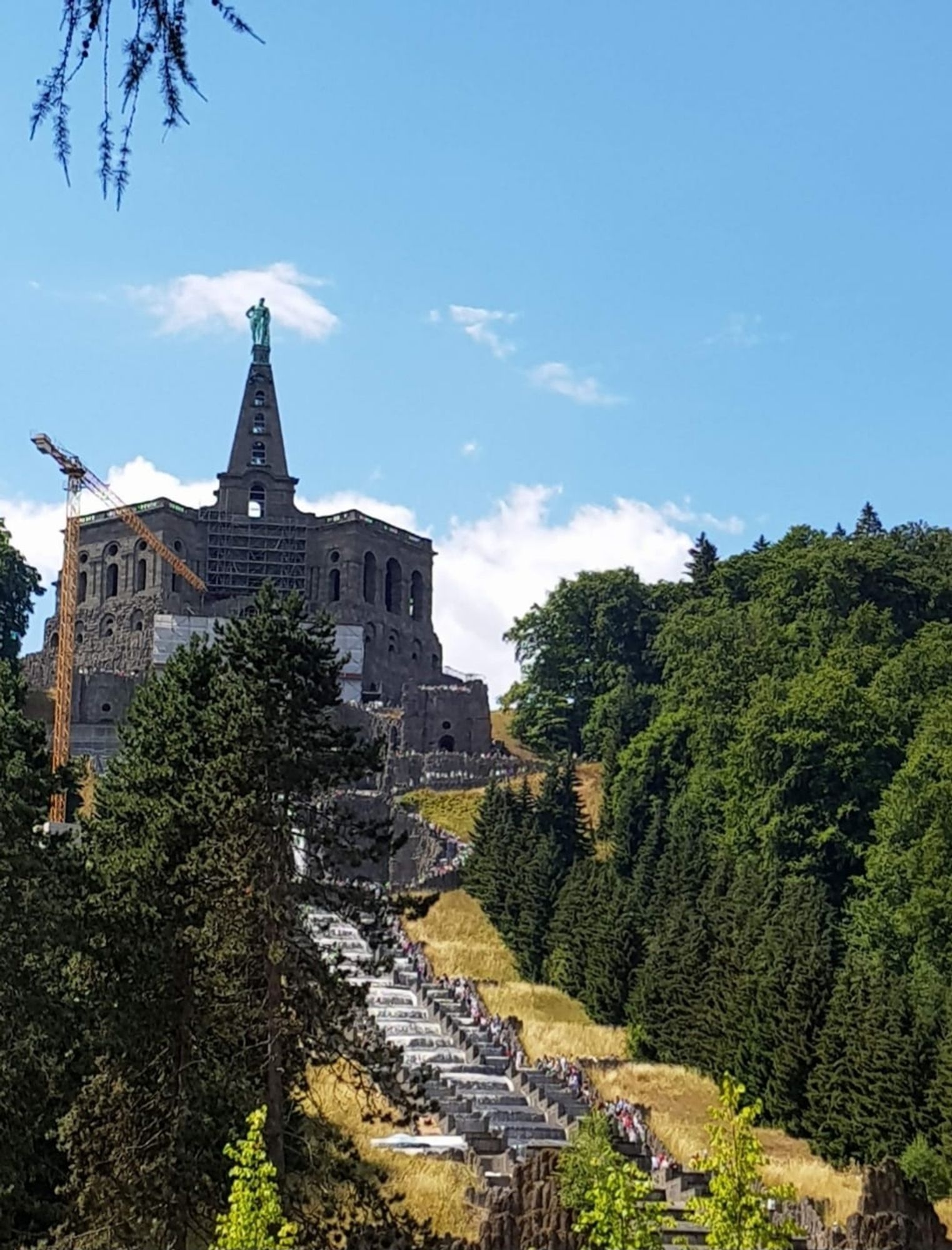 Gebäude auf einer Anhöhe mit Turmspitze
drumherum Park