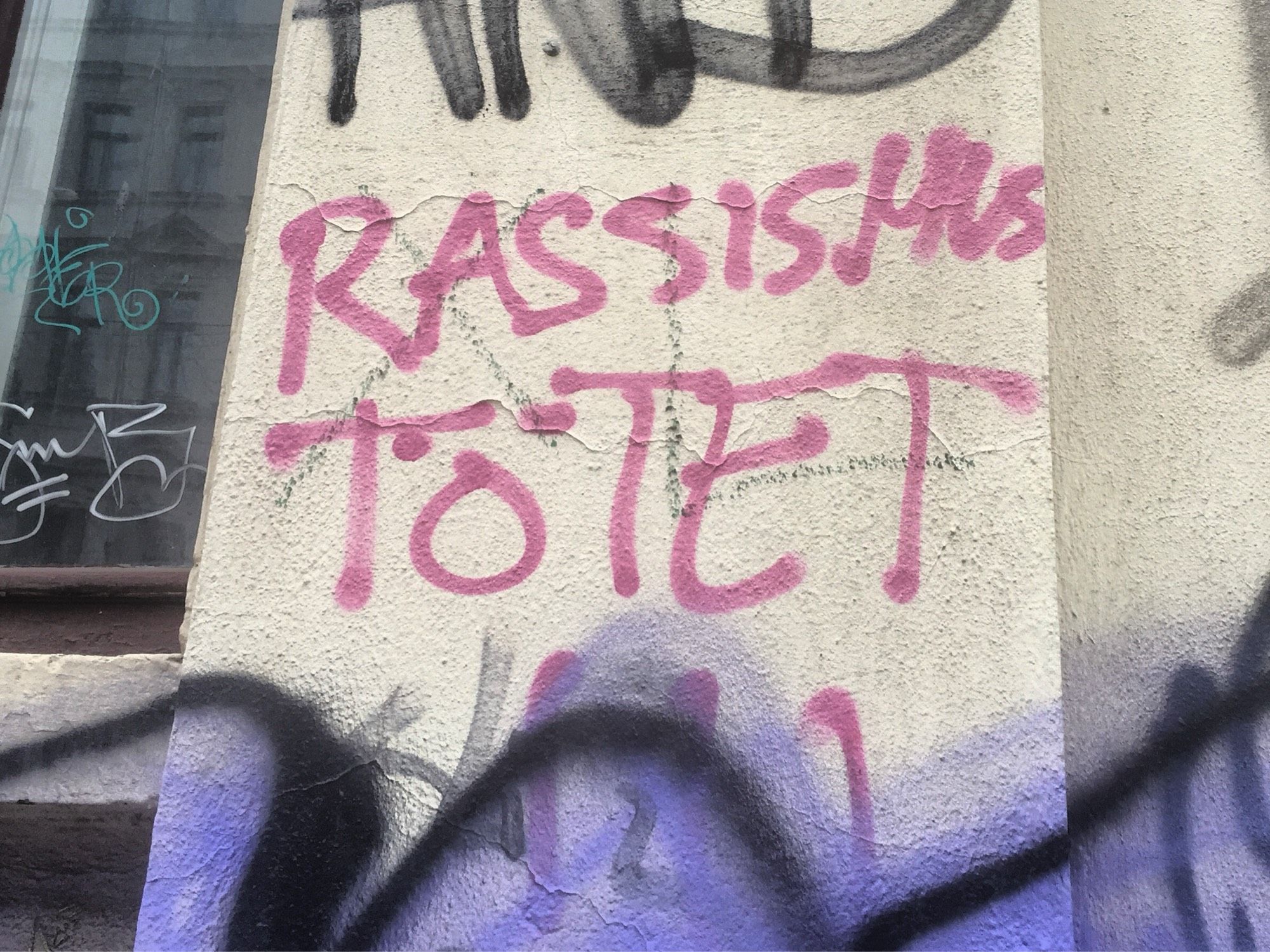 An einer Wand steht "RASSISMUS TÖTET"