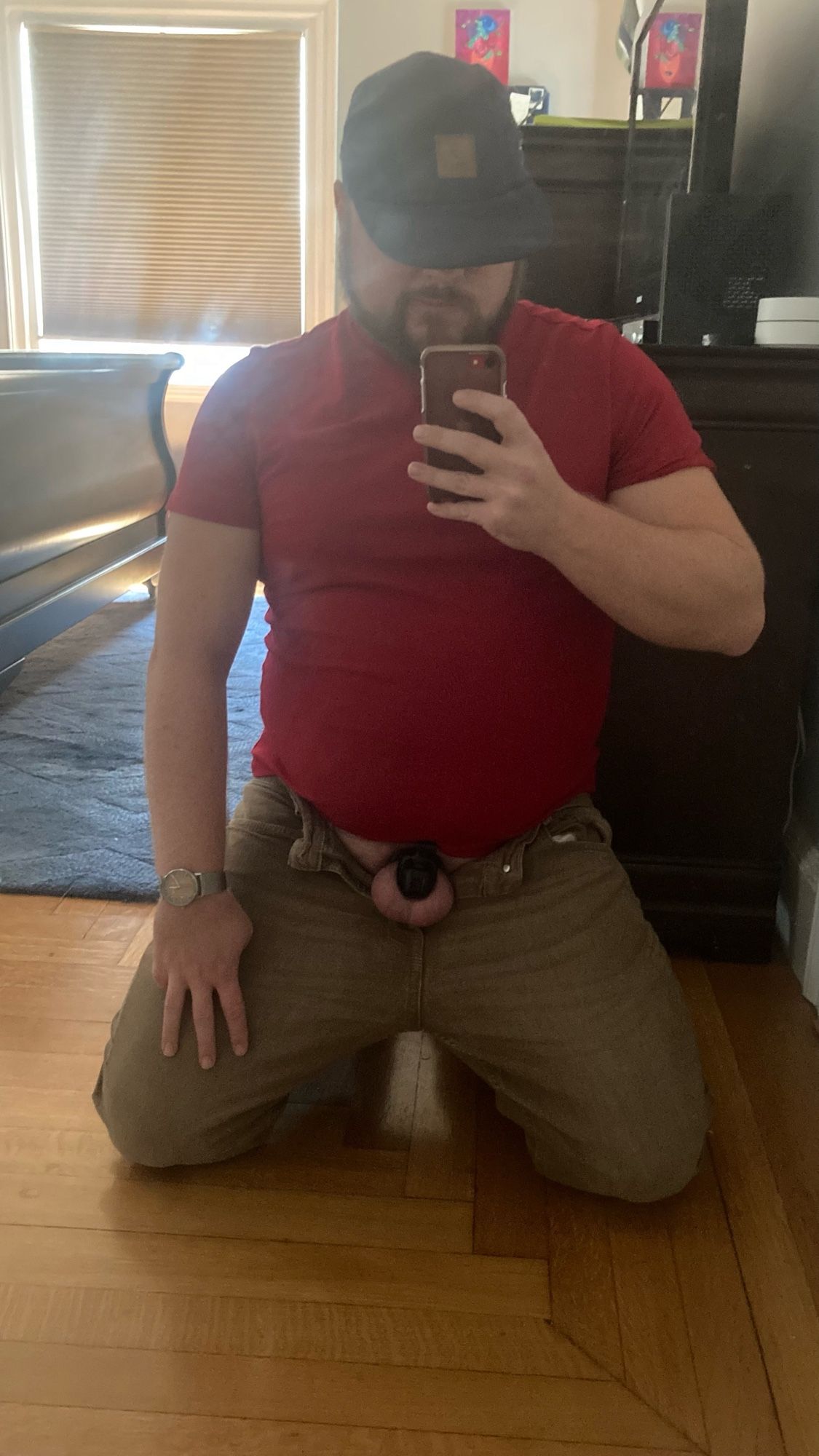 Me on my knees with my locked cock hanging out of my jeans and a hat pulled low over my eyes.