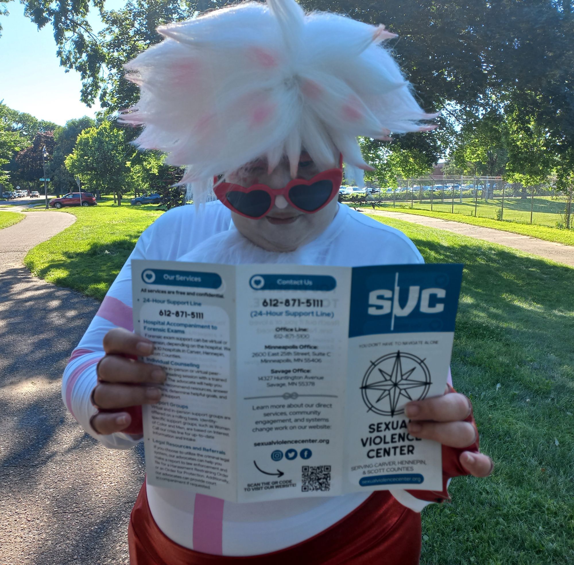 Angel Dust cosplayer reading a brochure for Minnesota's Sexual Violence Center.