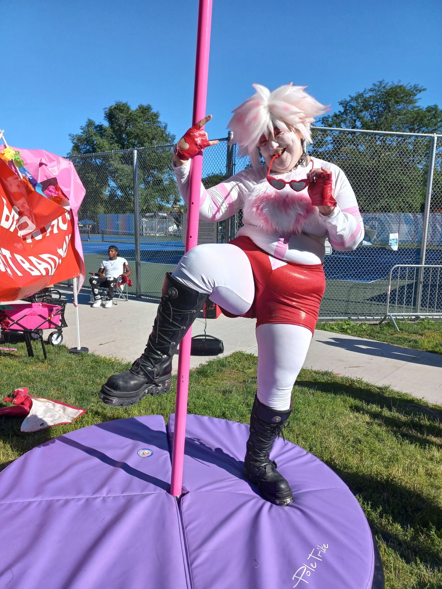 Angel Dust cosplayer on a pole dancing pole.