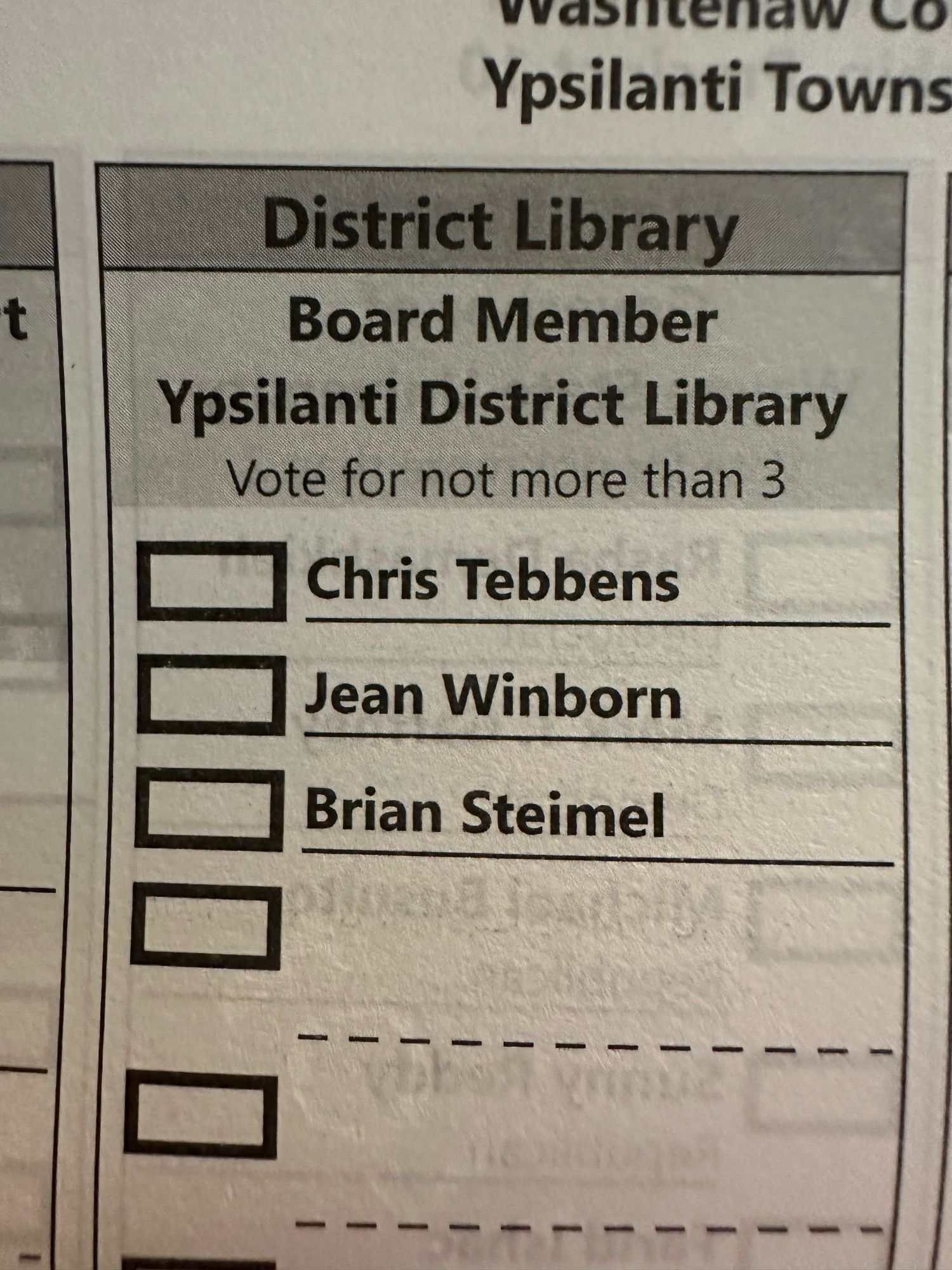 Part of a ballot. The section is “Board Member Ypsilanti District Library”, and individuals are instructed to vote for not more than 3. There are three names with boxes next to them, Chris Tebbens, Jean Winborn, and Brian Steimel.