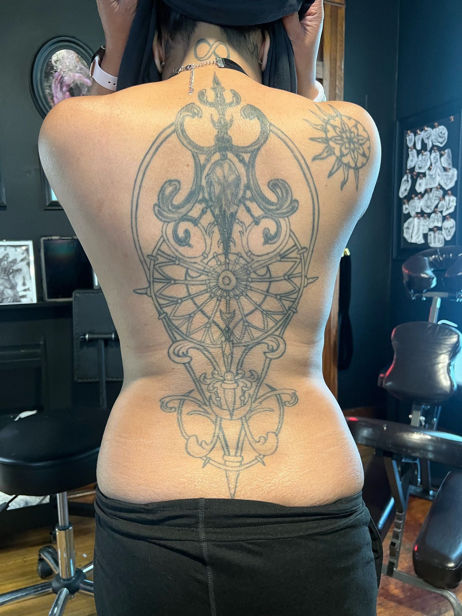 A full back tattoo partially complete that features a corvid skull near the top and is designed to look like ironwrought gate.