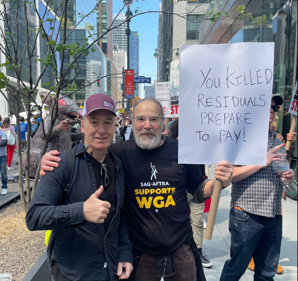 Mandy holding a sign on the picket line that reads "you killed residuals, prepare to pay!"