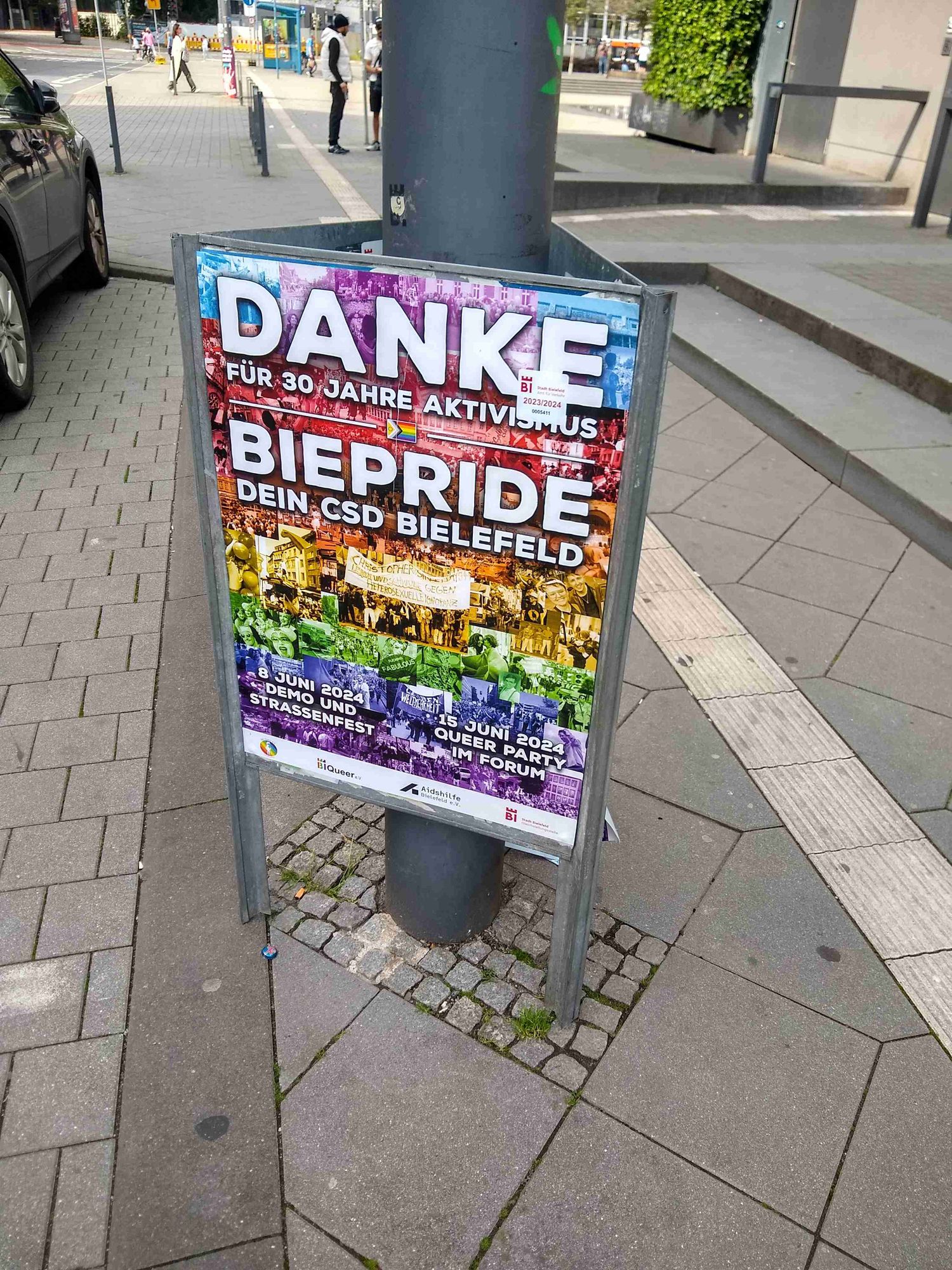 Eine Straßenschild, dass den CSD in Bielefeld bewirbt. Es steht drauf: "Danke für 30 Jahre Aktivismus - Biepride CSD in Bielefeld"