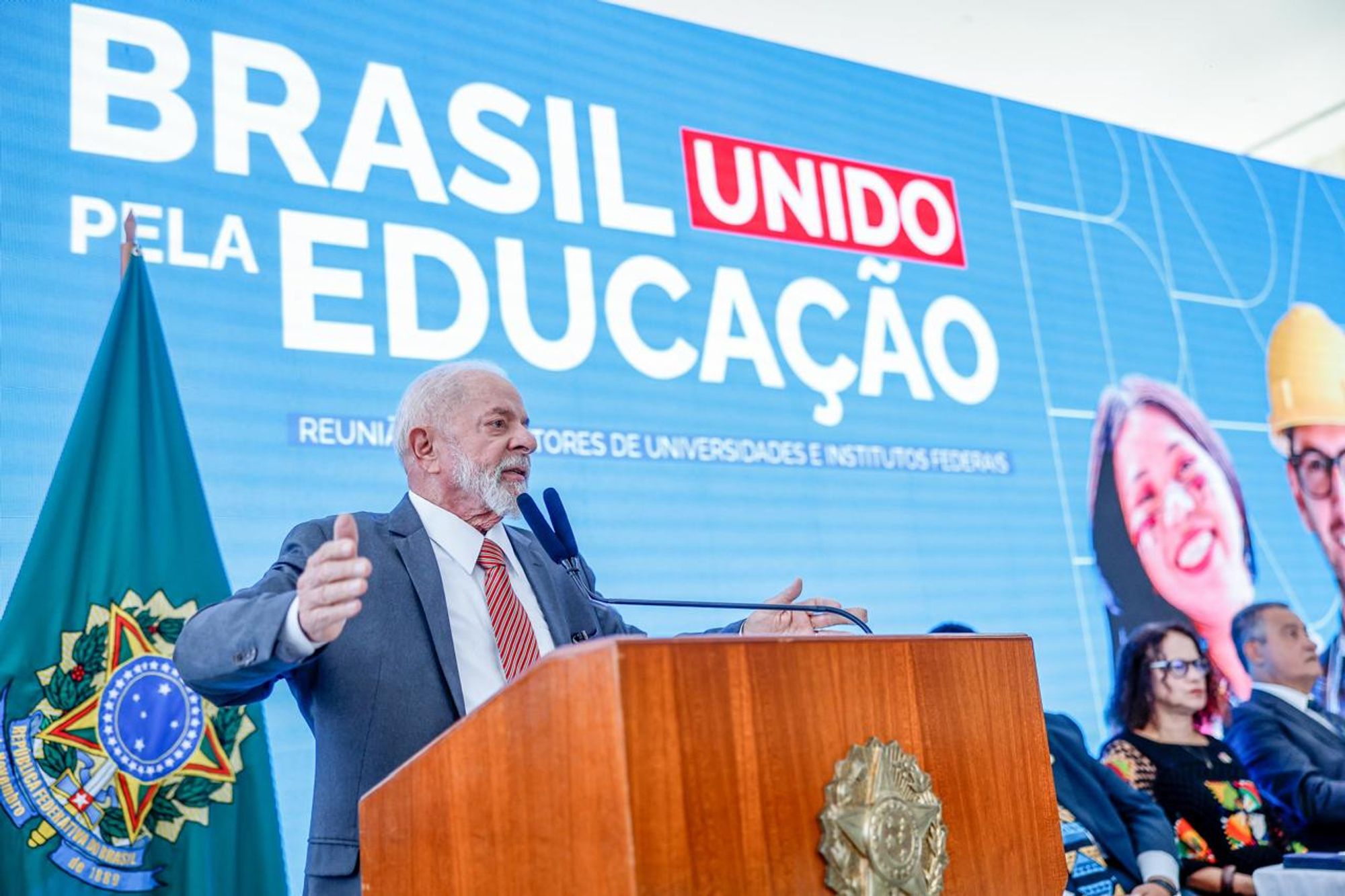 Presidente Lula discursando durante reunião com reitoras e reitores das Universidades e Institutos Federais. Ao fundo o texto no telão: Brasil unido pela educação.