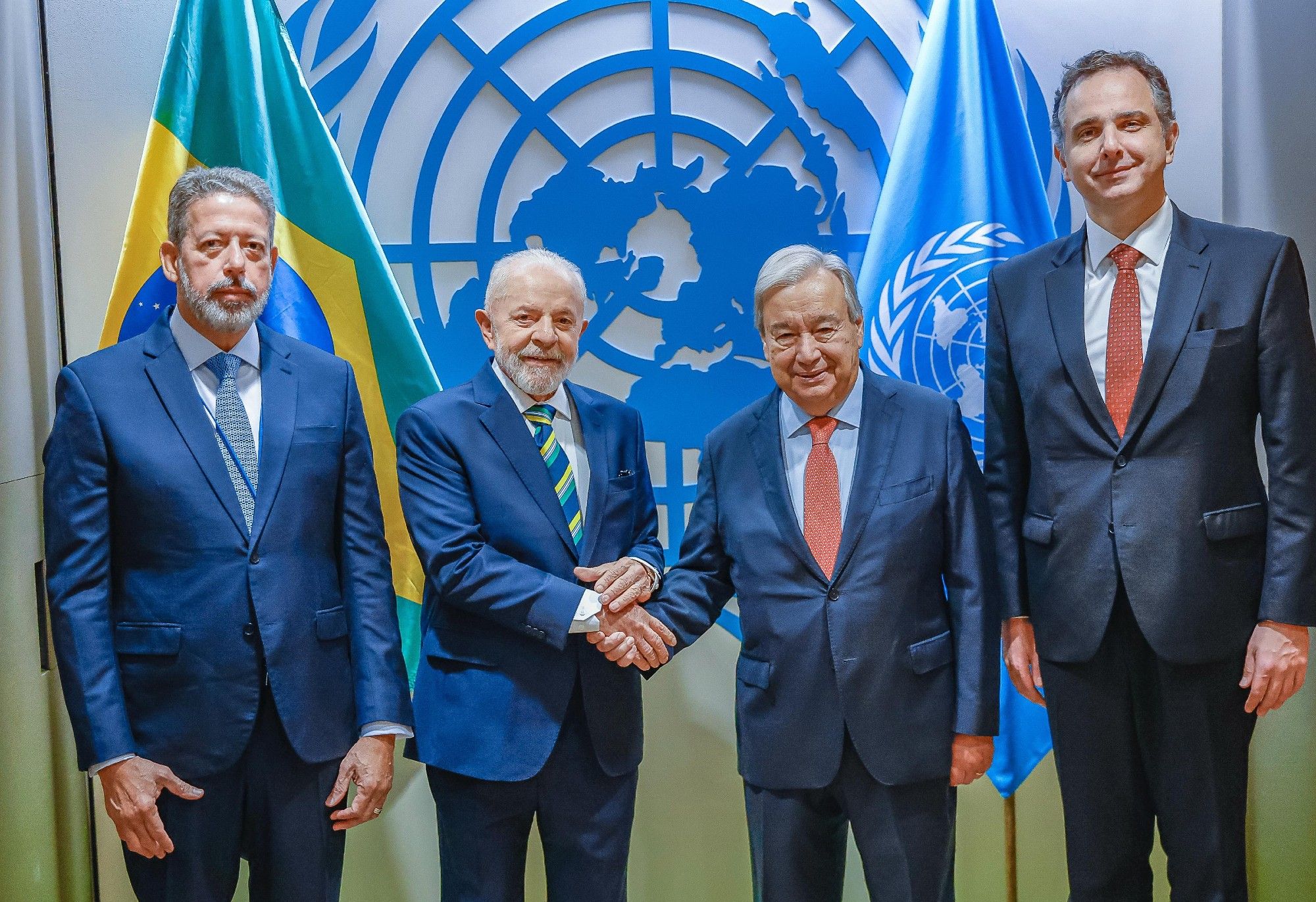 Na foto, o presidente Lula está de mãos dadas com o secretário-geral das Nações Unidas, António Guterres. Ao lado dos dois, o presidente da Câmara dos Deputados Arthur Lira e o presidente do Senado, Rodrigo Pacheco. Ao fundo, as bandeiras do Brasil e da ONU.