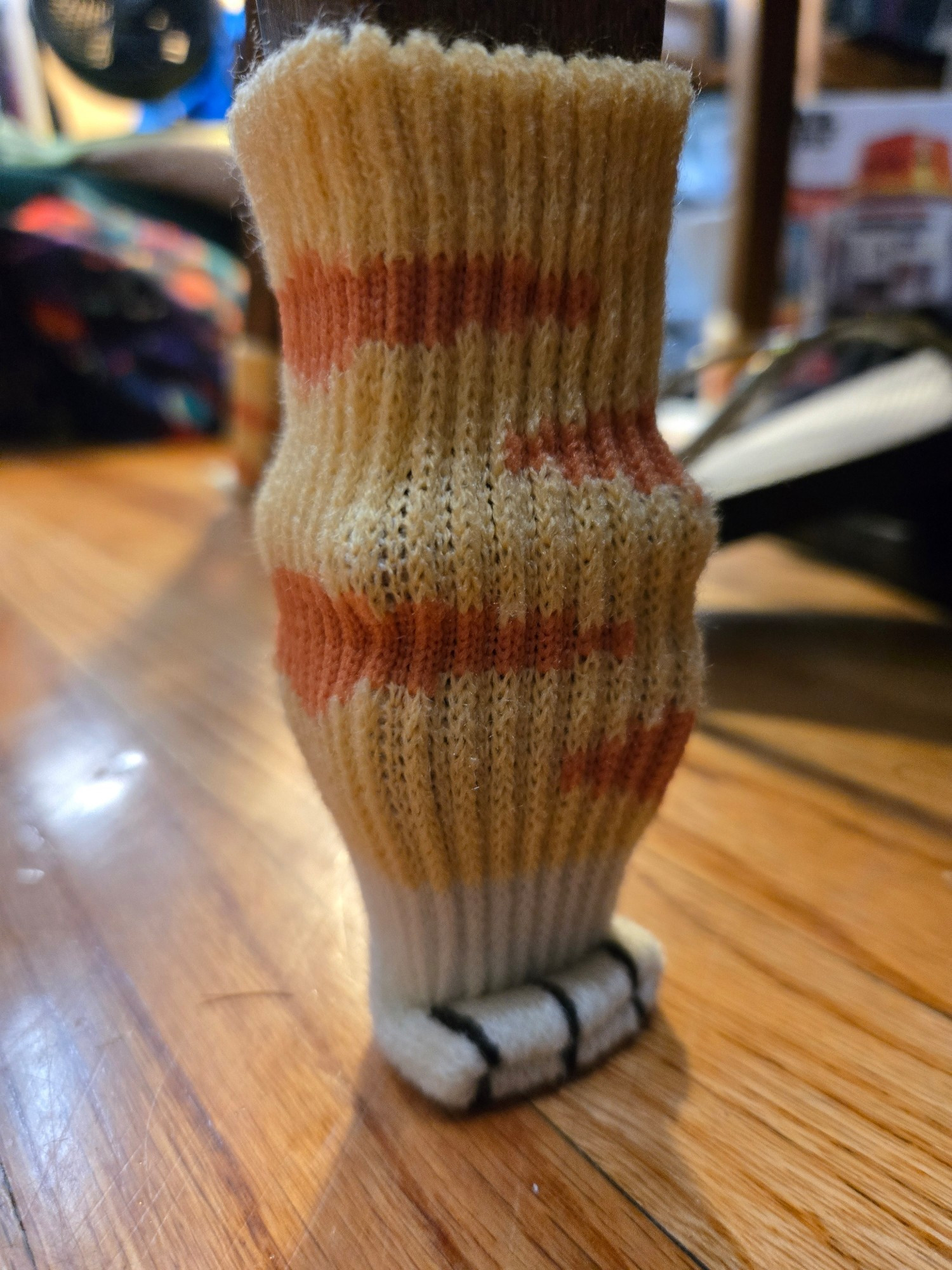 Photo of a chair leg with a cat foot design dock on the end. The chair leg has a rounded tapered design that makes it look like the cat leg has a pronounced calf muscle.