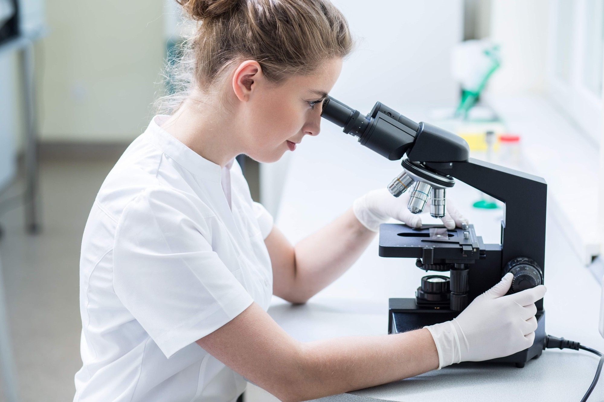 Woman looking into a microscope.