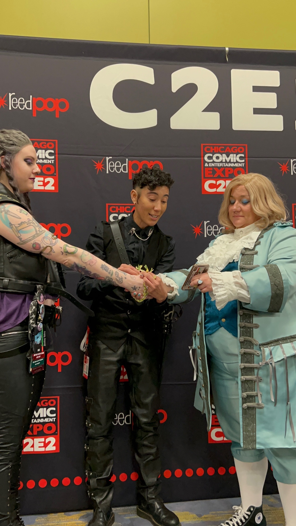 Vico Ortiz dressed as Izzy Hands performs a handfasting ribbon ceremony for fans cosplaying Ed and Stede