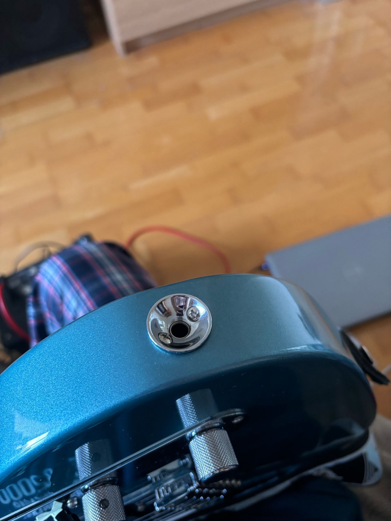 A modded Telecaster jack input with two screws securing it to the body, fitted to a Fender Telecaster in tidepool blue