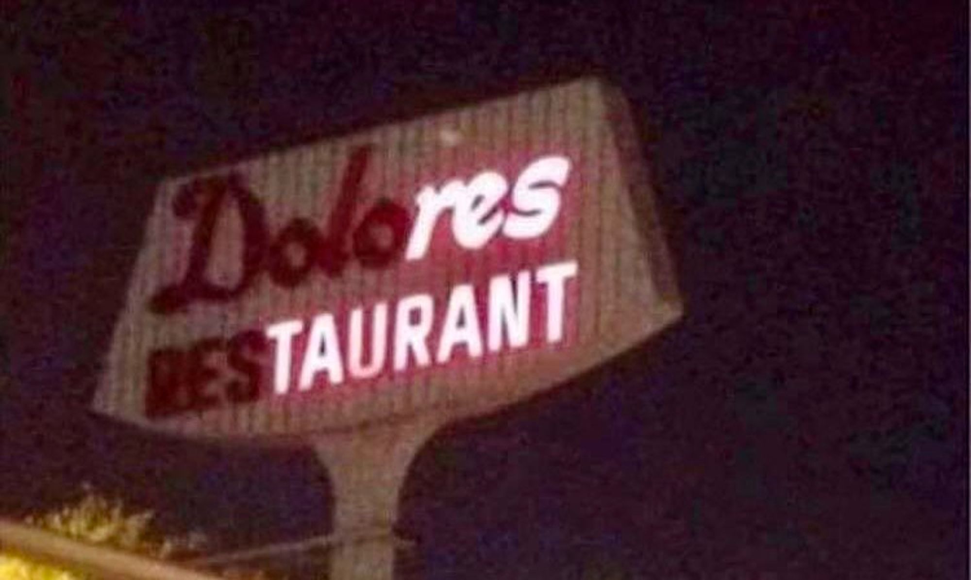 A neon sign for Dolores Restaurant with the letters DOLO burned out in Dolores and the letters RES burned out in restaurant, so that the lighted neon sign still successfully communicates that it is a res-taurant. (original source of photo regrettably unknown).