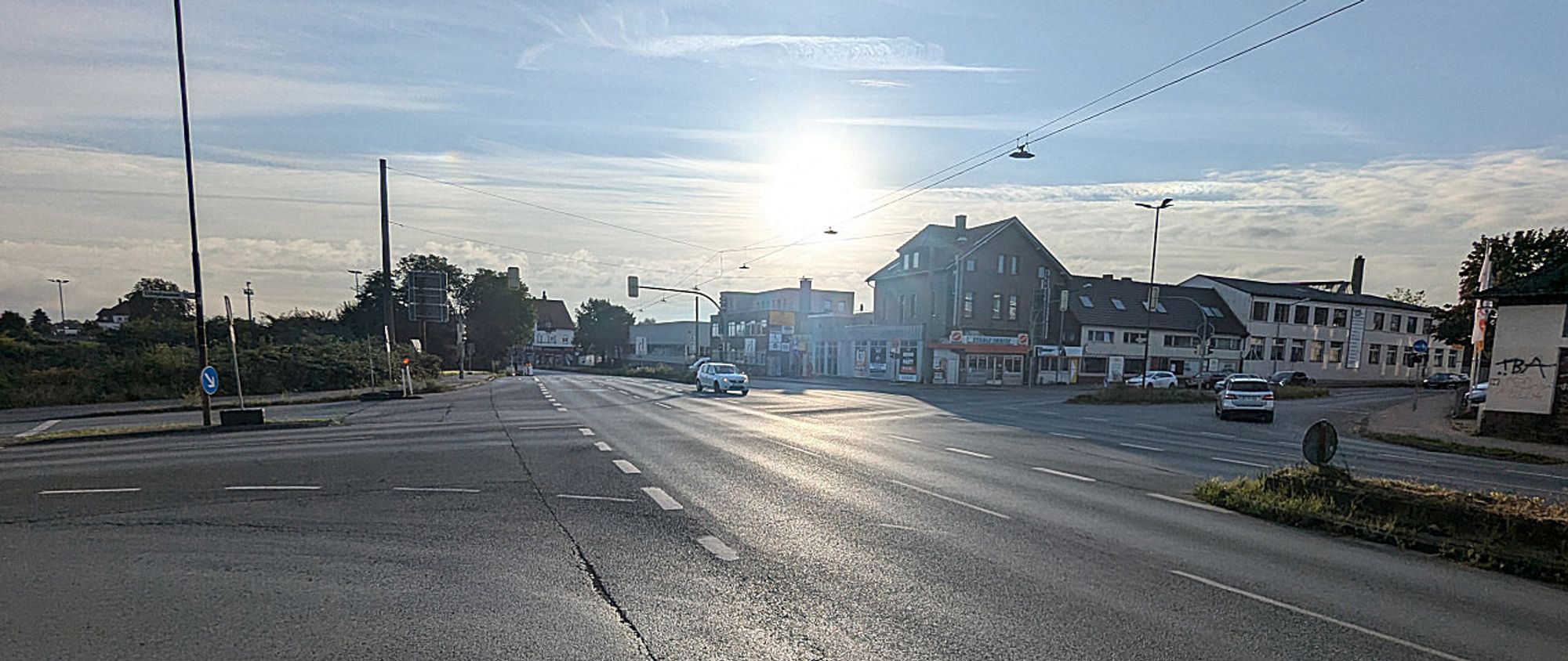 Eine leere Kreuzung mit gesonderten Links-, Rechts- und zwei Geradeausspuren je Fahrtrichtung morgens um viertel nach Acht.