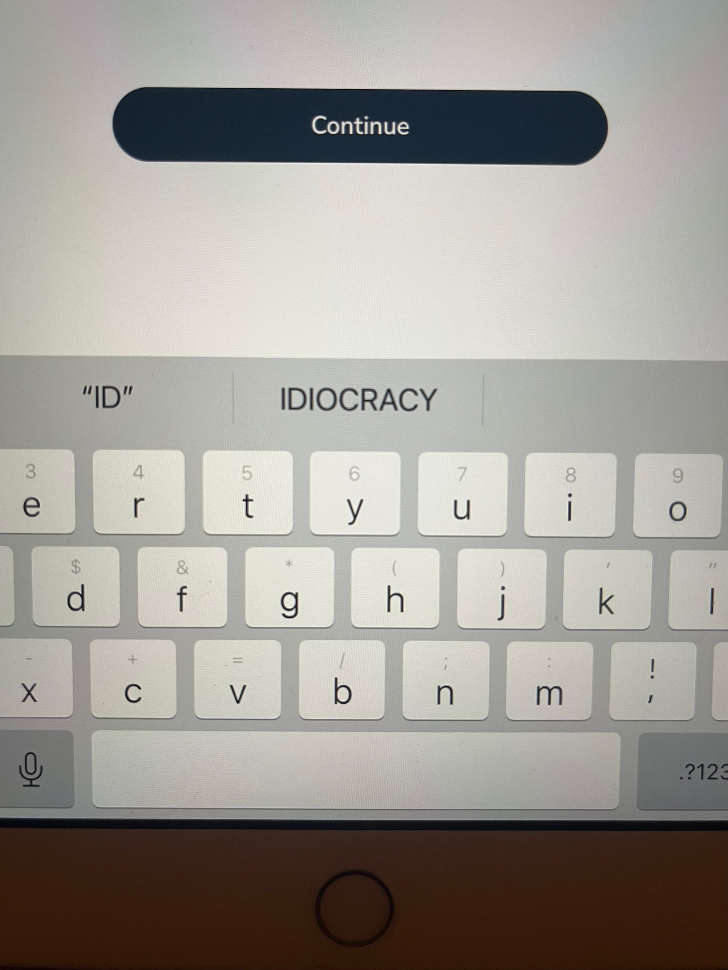 Screenshot of a partial tablet keyboard with the word “idiocracy” centered above it and the abbreviation “ID” to the left of it. 