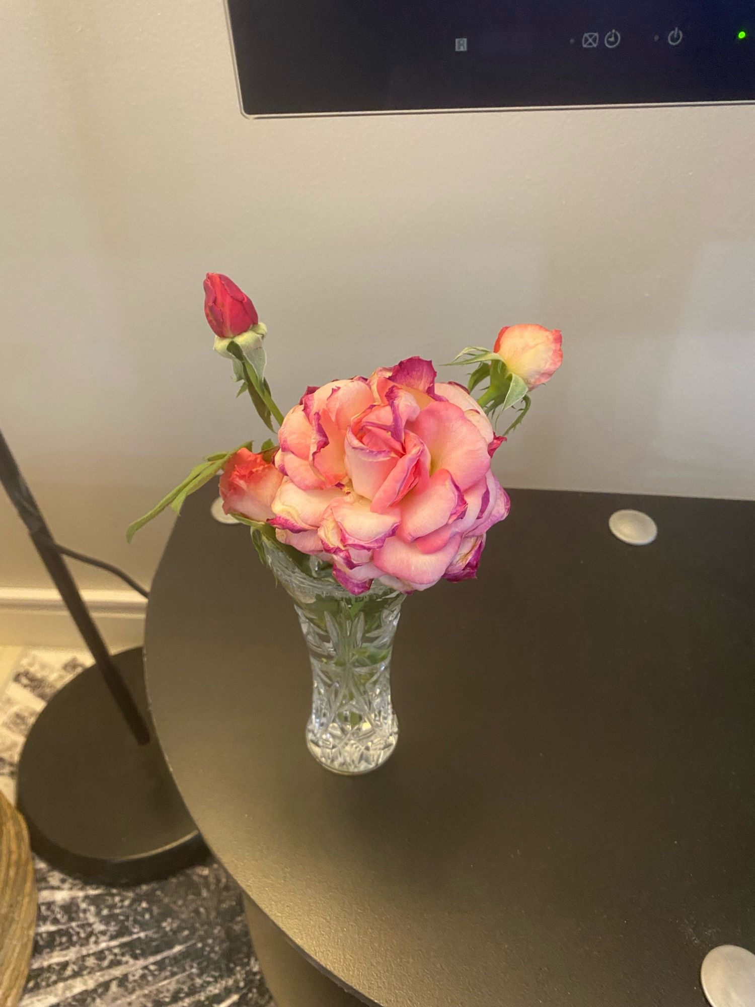 A few beautiful pale pink roses in a small crystal vase.