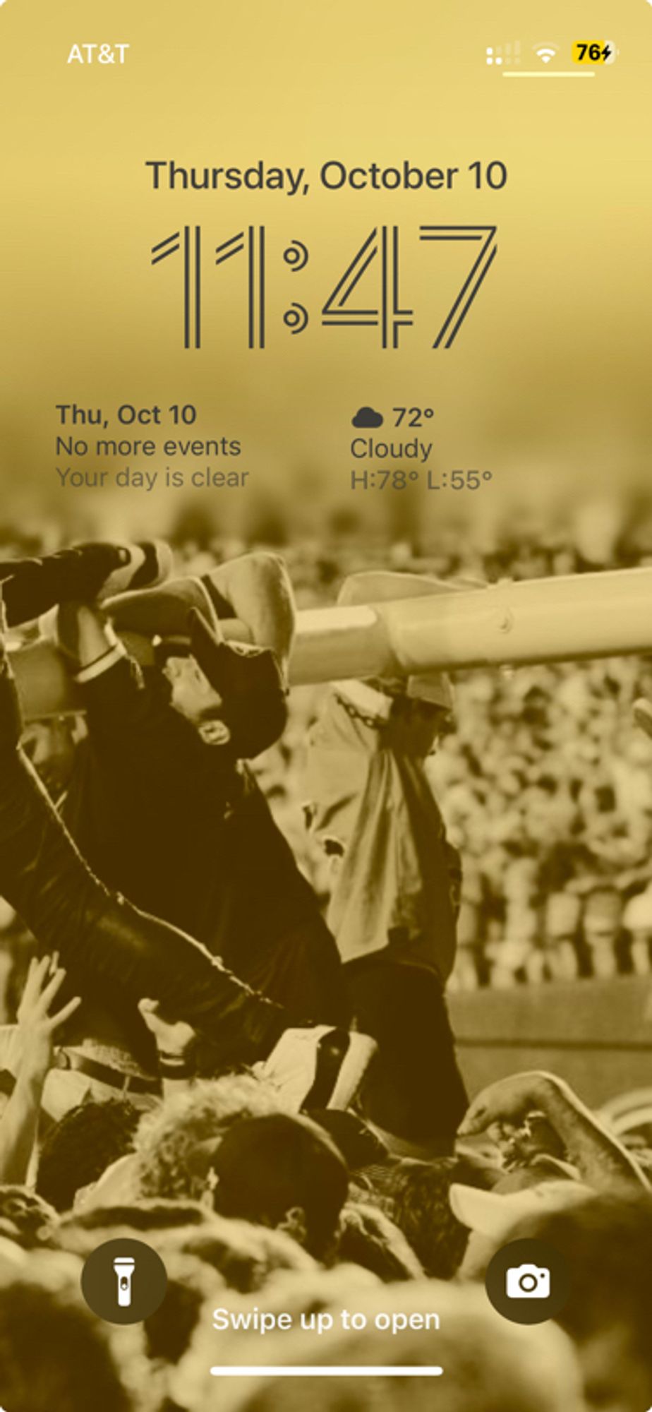 An iPhone 13 mini with a gold-tone picture of the Vandy students ripping down the goalposts as wallpaper