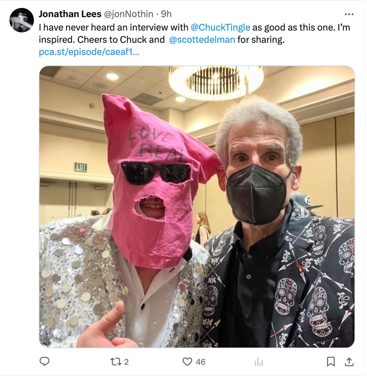 A tweet which reads, "I have never heard an interview with @ChuckTingle as good as this one. I'm inspired. Cheers to Chuck and @scottedelman for sharing." And then there's a link: https://pod.link/1083737796. There is a photo of me and Chuck from StokerCon. He's in a silver mirrored jacket, I'm in black and covered with white Dia de Los Muertos skulls. He has his usual pink sack over his head with the words Love is Real, and I am wearing an N95.