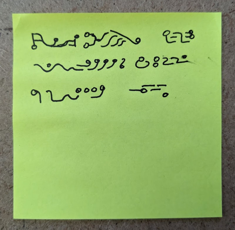 postit note with three lines of fake "alien" text, made of a variety of circles, lines, and squiggles