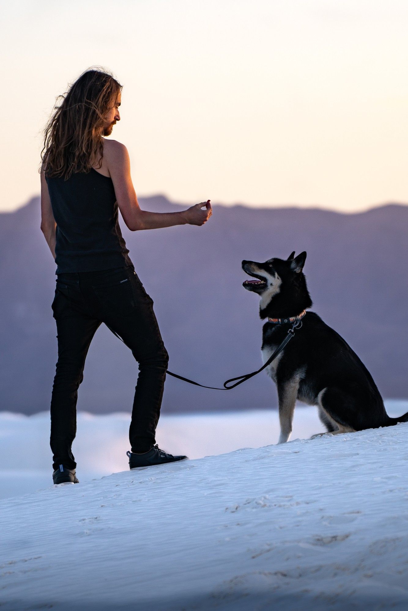 Standing in white sands as my dog sits for a treat because he is a very good boy.