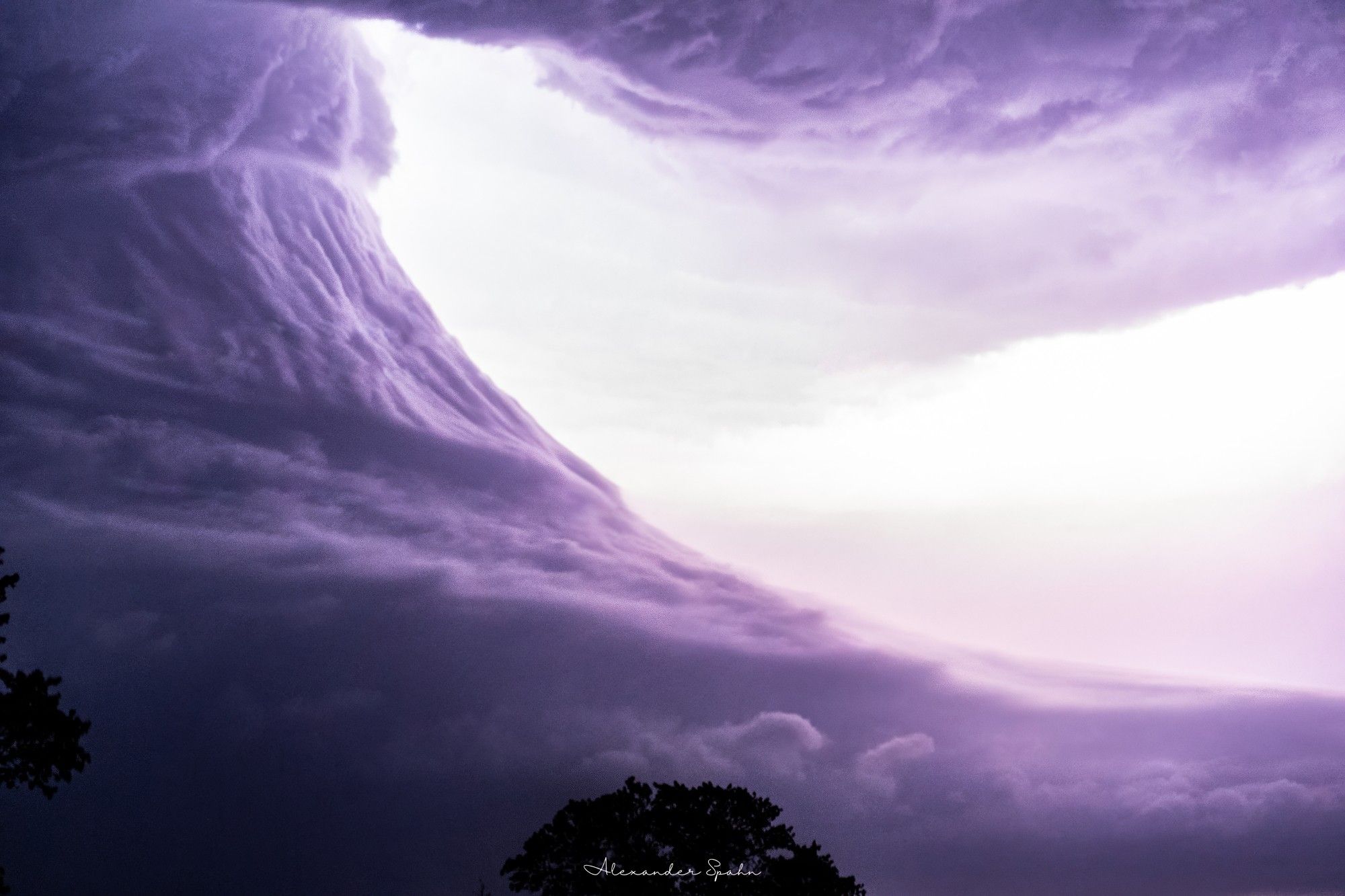 The bell-shaped updraft of a powerful supercell is illuminated by lightning.