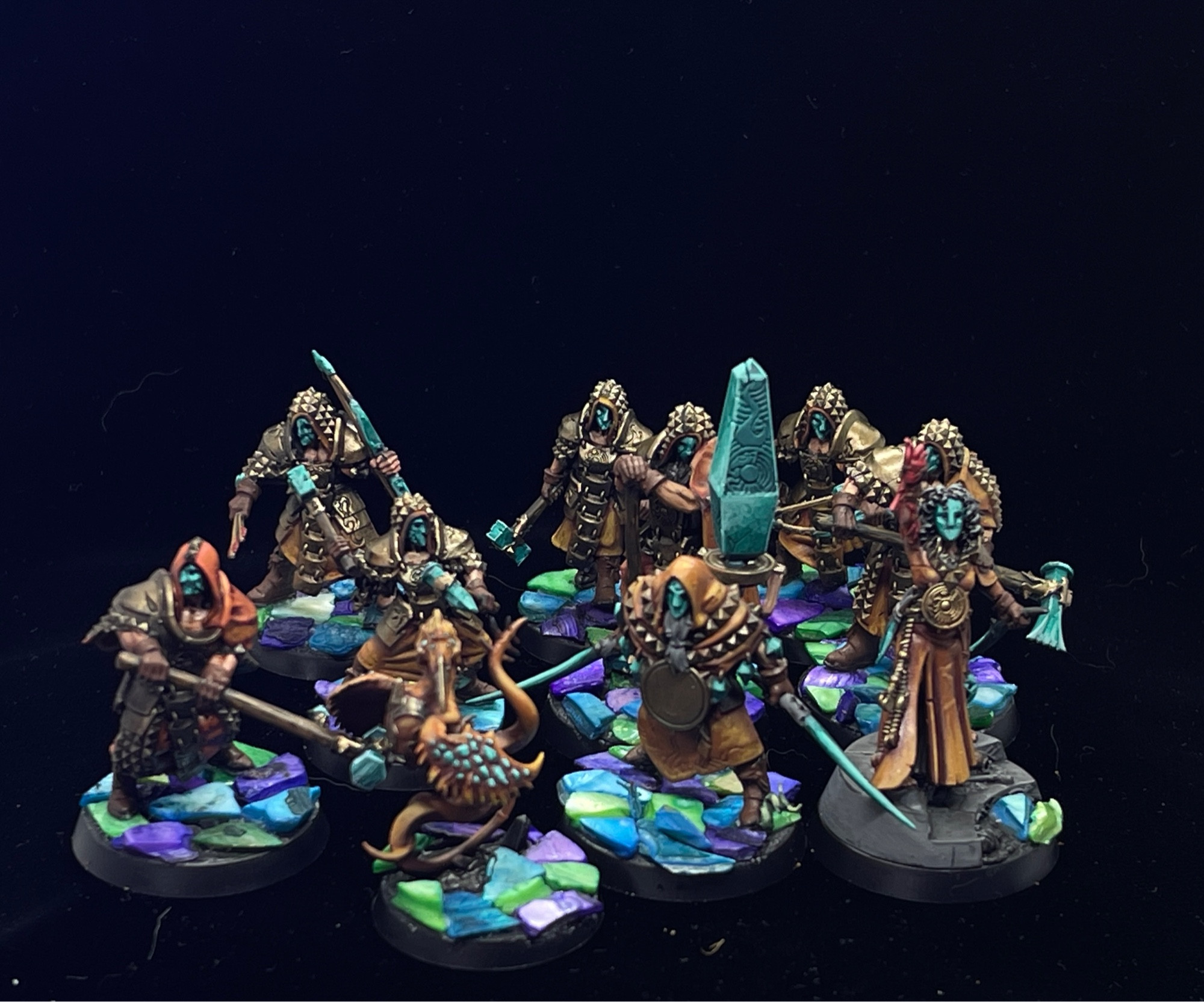 Miniatures from Warcry called The Jade Obelisk. Bases done with a mosaic style made of colorful shards of seashell.