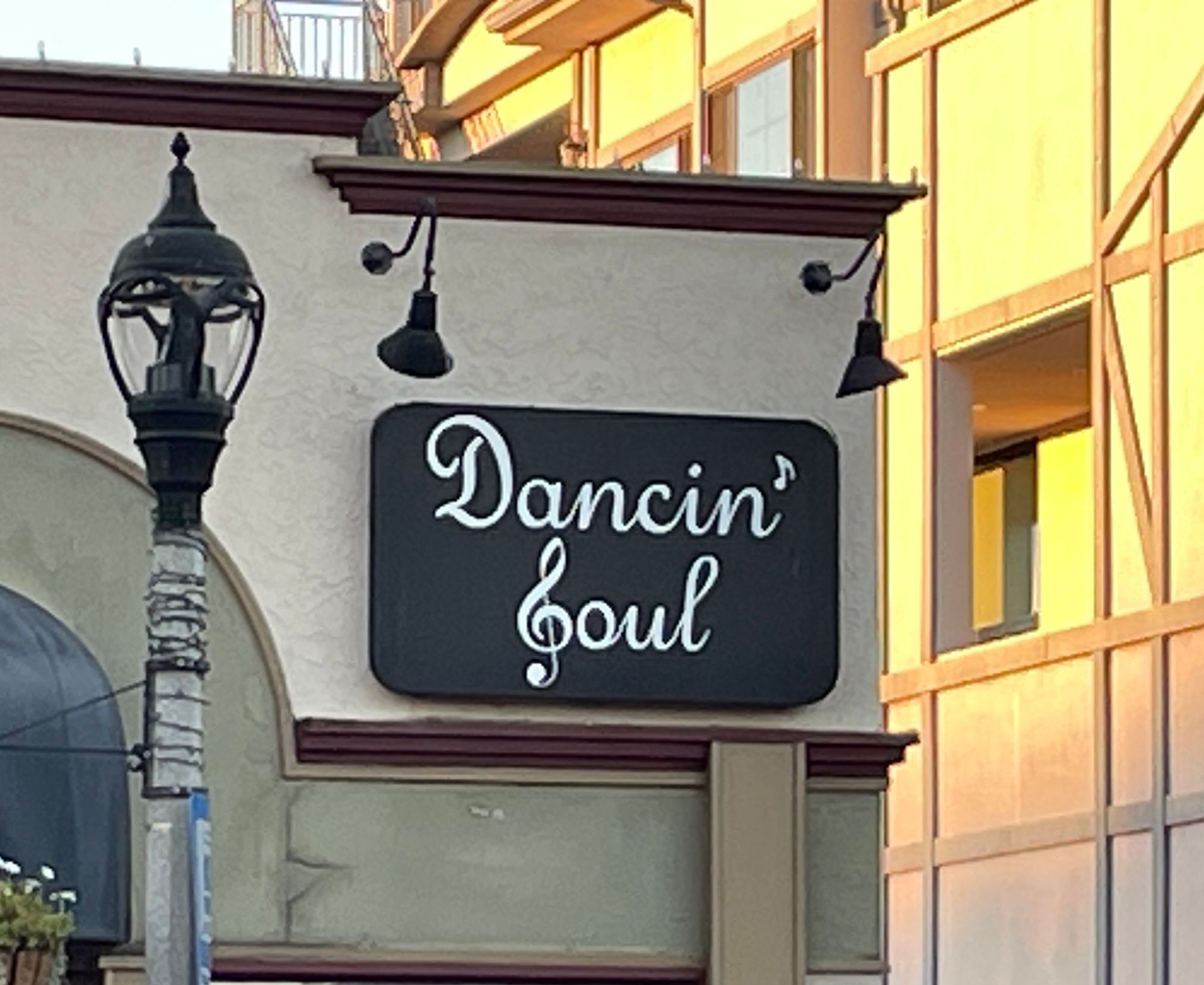 A shop sign for “Dancin’ Soul” using a stylized “G” (as on a treble clef staff) as an “S”.