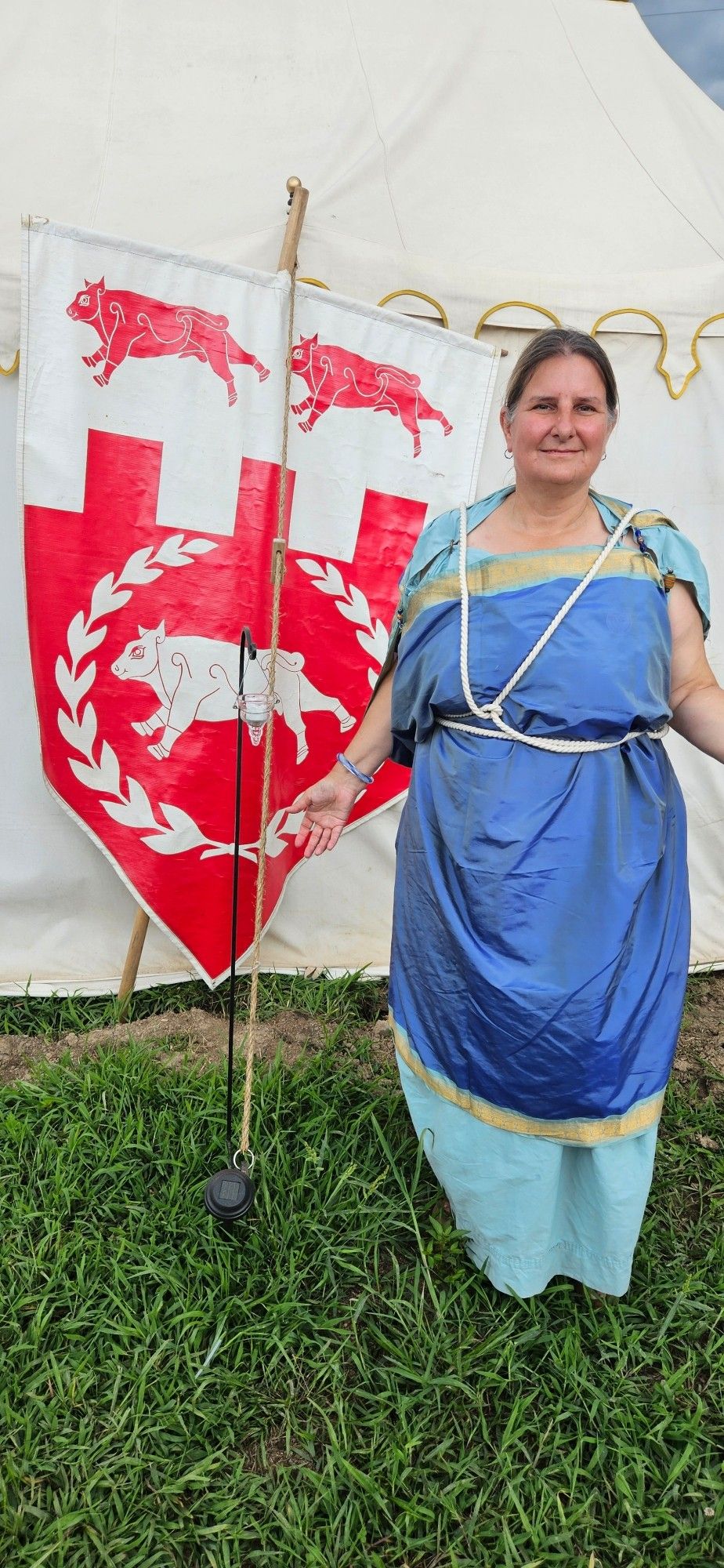 Woman in Greek-style chiton in front of banner with bulls