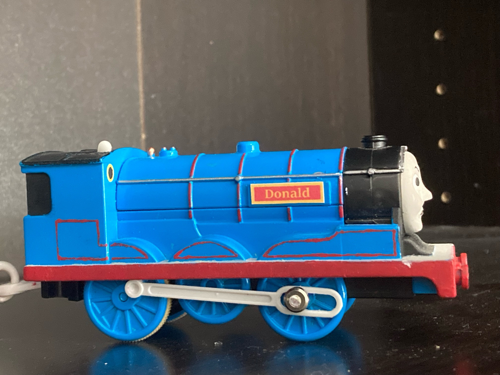 Side profile of Donald, his blue paint is fully visible alongside his red stripes. His nameplate is yellow and red and reads “Donald” in yellow text.