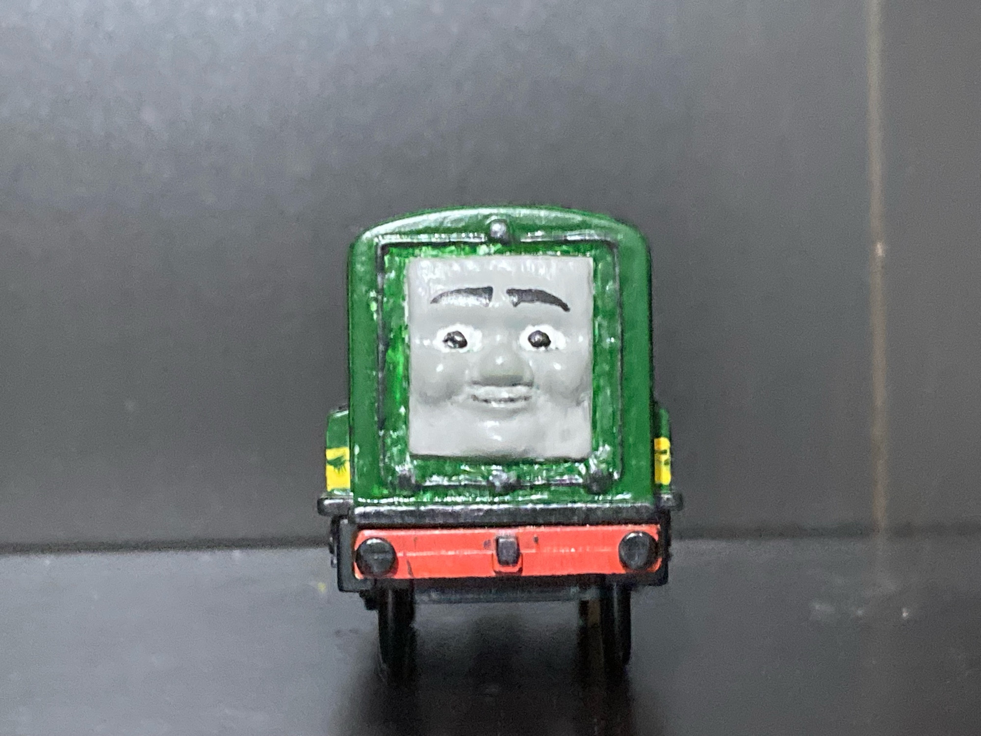 Paxton from Thomas and Friends as a TOMY Toy, he is smiling.

Paxton is painted green with two yellow stripes going across his main bodywork and has red side rods and a red bufferbeam.