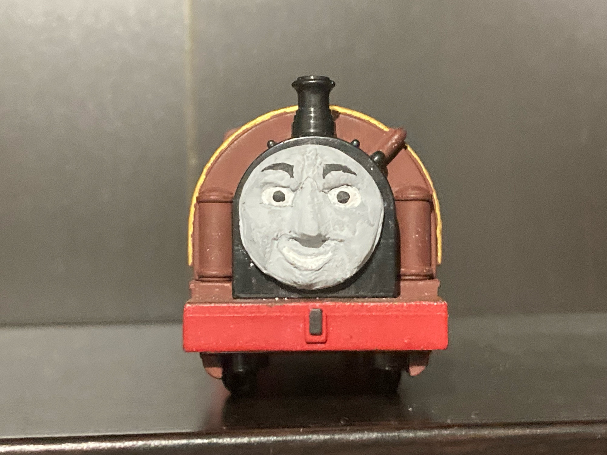 Front view of Bertram from Thomas and Friends as a TrackMaster Toy.

He is painted dark brown with gold lining and has a red bufferbeam.