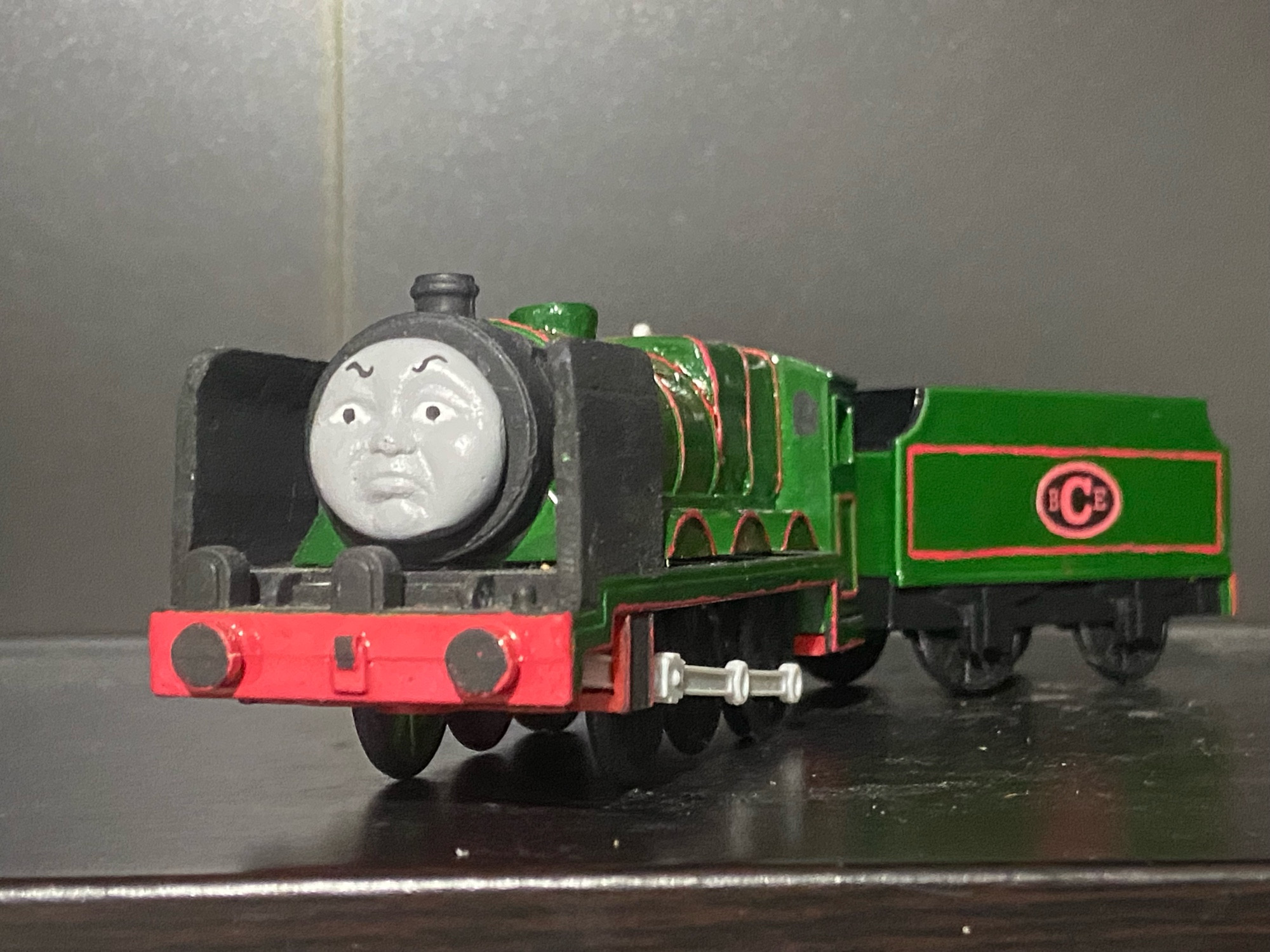 Side profile of the Big City Engine, he is painted dark green with red lining, there is a oval shape on his tender with the letters B C E written in Red Text, a direct rip from his Thomas Wooden Railway Toy.