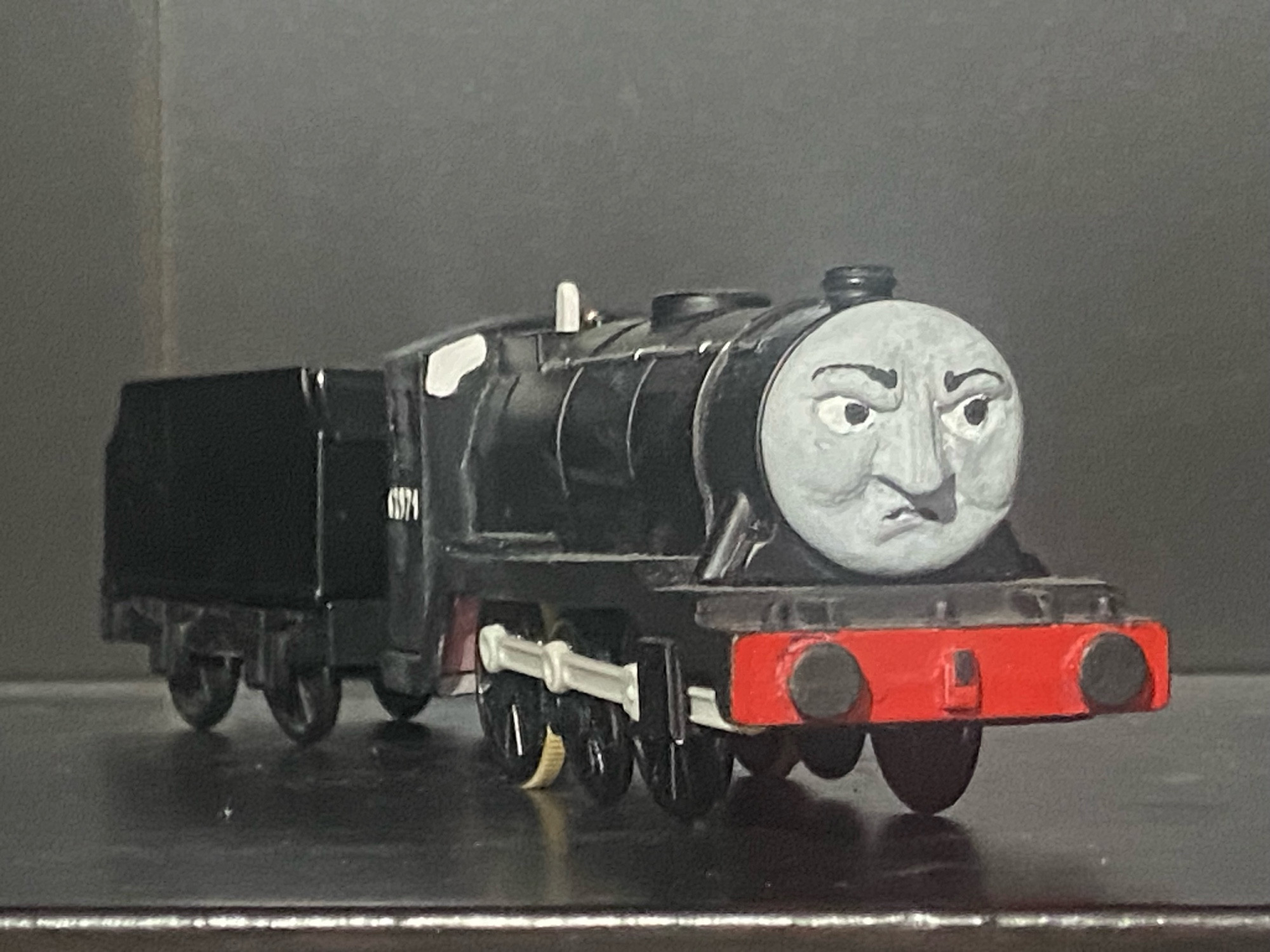 Side profile of Dudley. He is painted black with white cab portholes with the number 63971 written on the side of his cab in white. The only other bit of color on him is his front bufferbeam, which is painted red.