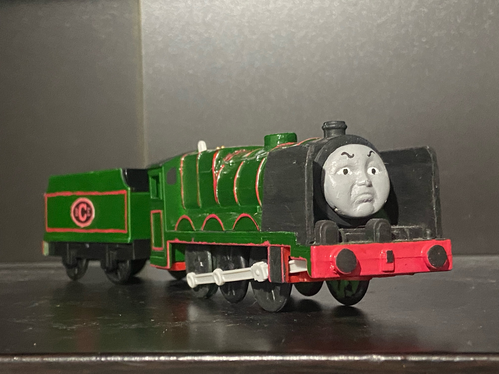 Side profile of the Big City Engine, he is painted dark green with red lining, there is a oval shape on his tender with the letters B C E written in Red Text, a direct rip from his Thomas Wooden Railway Toy.