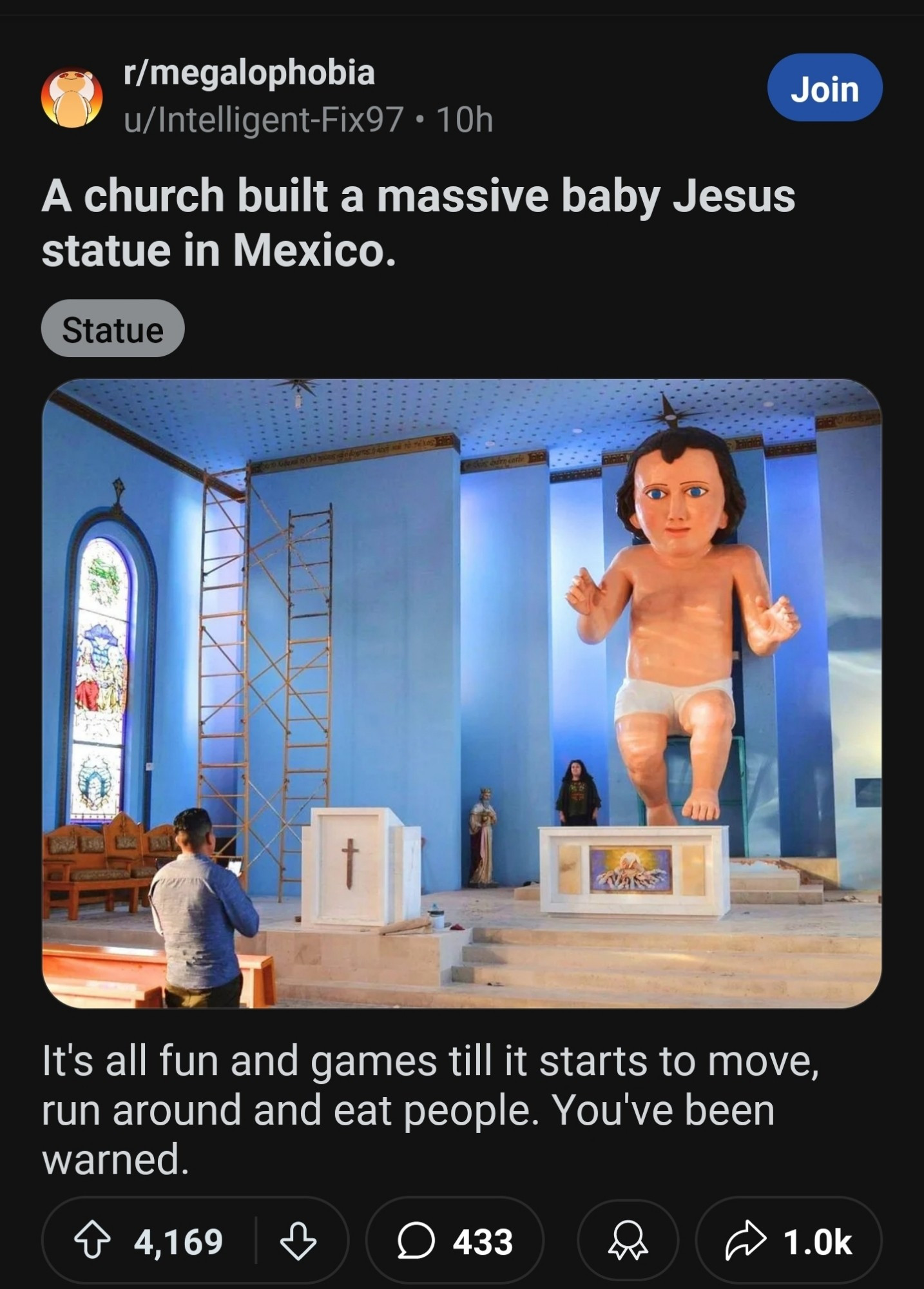 A post in the "megalophobia" subreddit of a giant sculpture in a church that's supposed to be baby Jesus but instead sort of looks like Kevin Dunn?