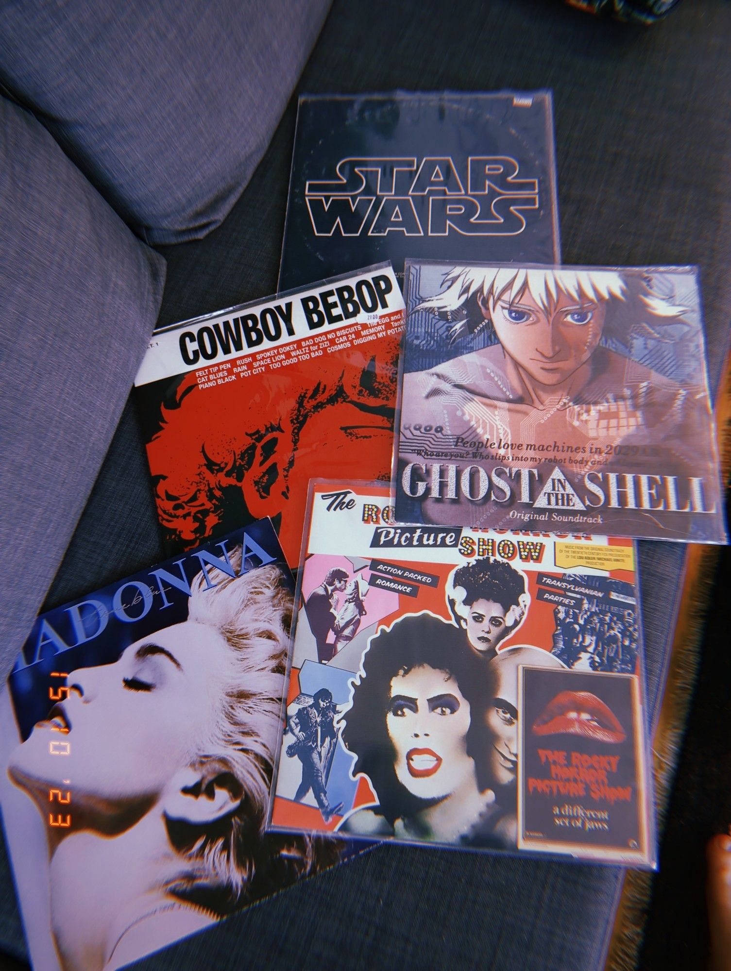 5 Platten liegen auf einem Sofa: Der Star Wars Soundtrack, Cowboy Bebop Soundtrack, Ghost in the Shell Soundtrack, Rocky Horror Picture Show Soundtrack und Madonna: true blue.