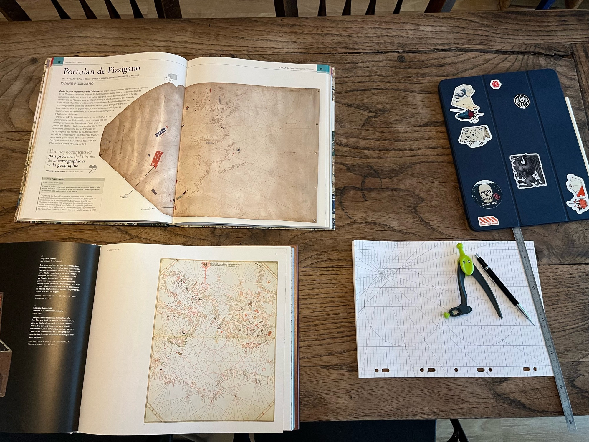 A couple of books showing ancient maps, my iPad and graph paper plus some drawing tools