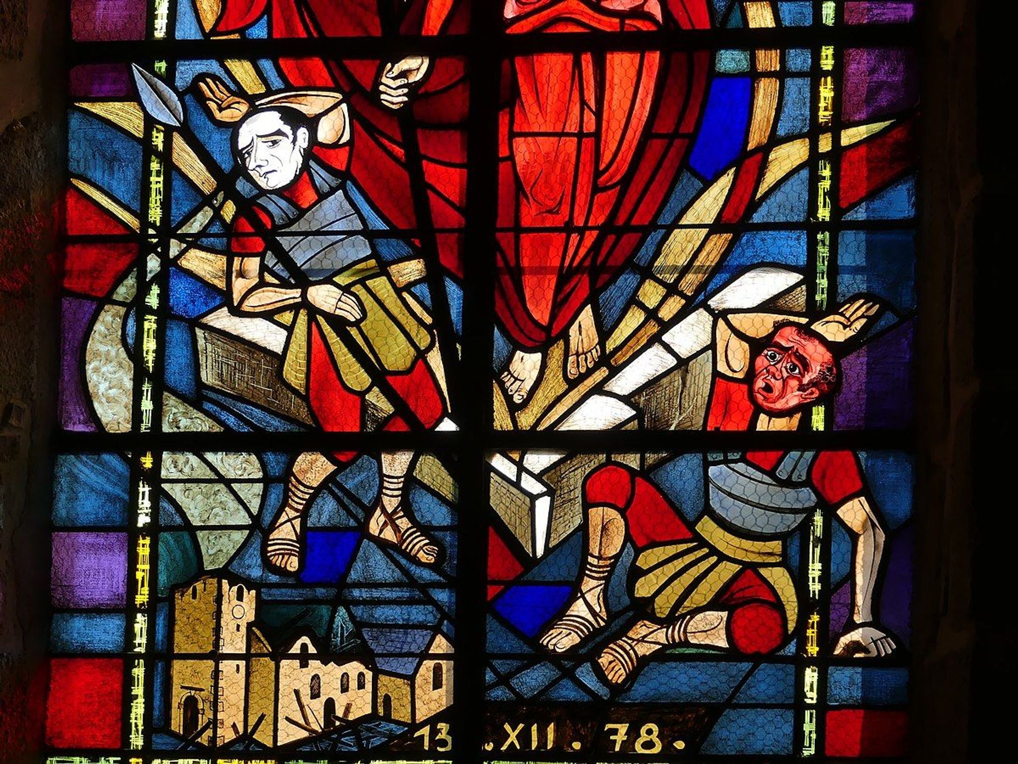 Détail du vitrail de l’Église Saint-Pierre-et-Saint-Paul d’Izé montrant des légionnaires en armure devant une église ravagée. Les couleurs vives du vitrail, incluant des rouges, bleus et jaunes, mettent en valeur les figures historiques et l’architecture de l’église en arrière-plan. Une inscription en bas indique la date ‘13 XII 78’.