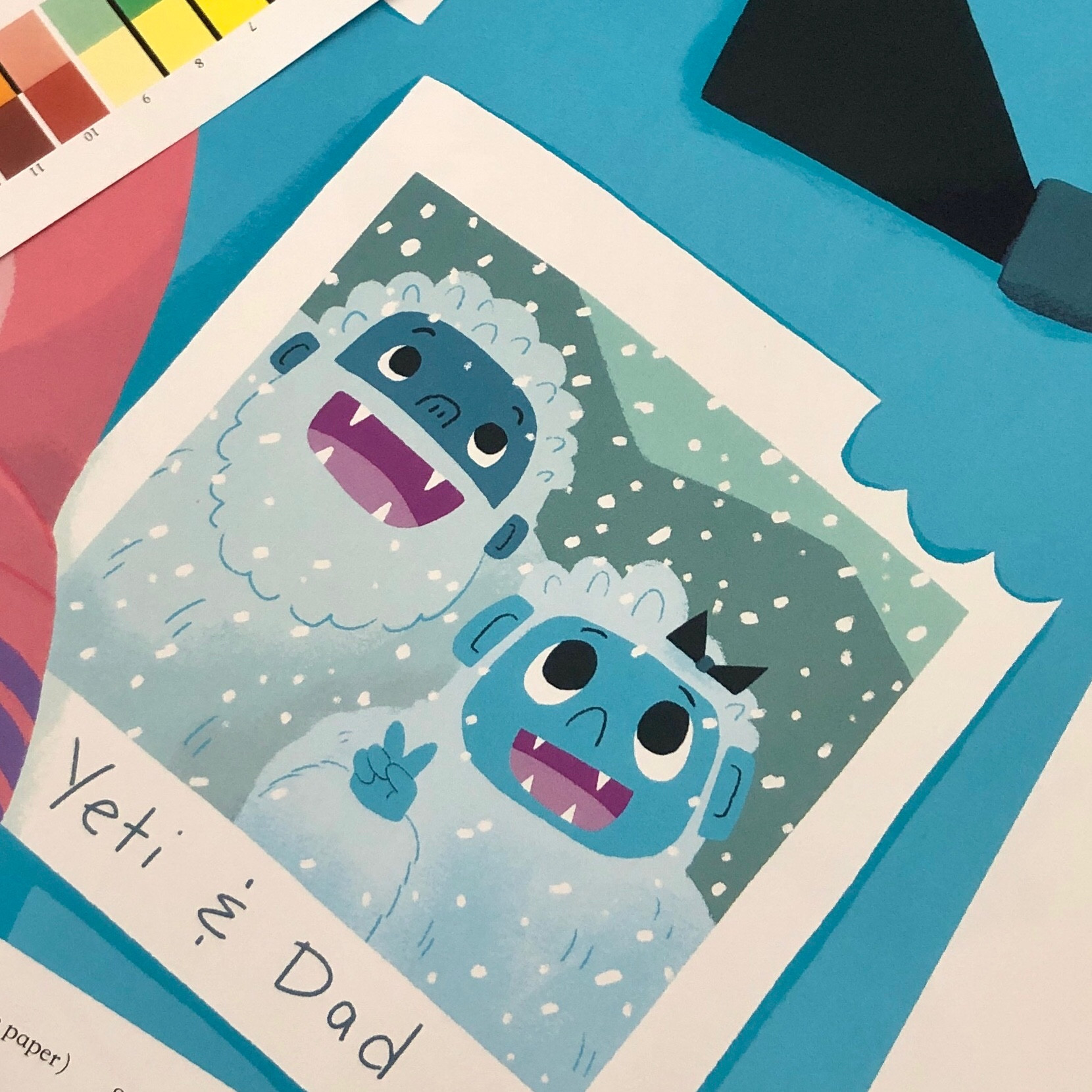 A flat lay of objects: there is a photo of Yeti and Dad smiling during a snowstorm.