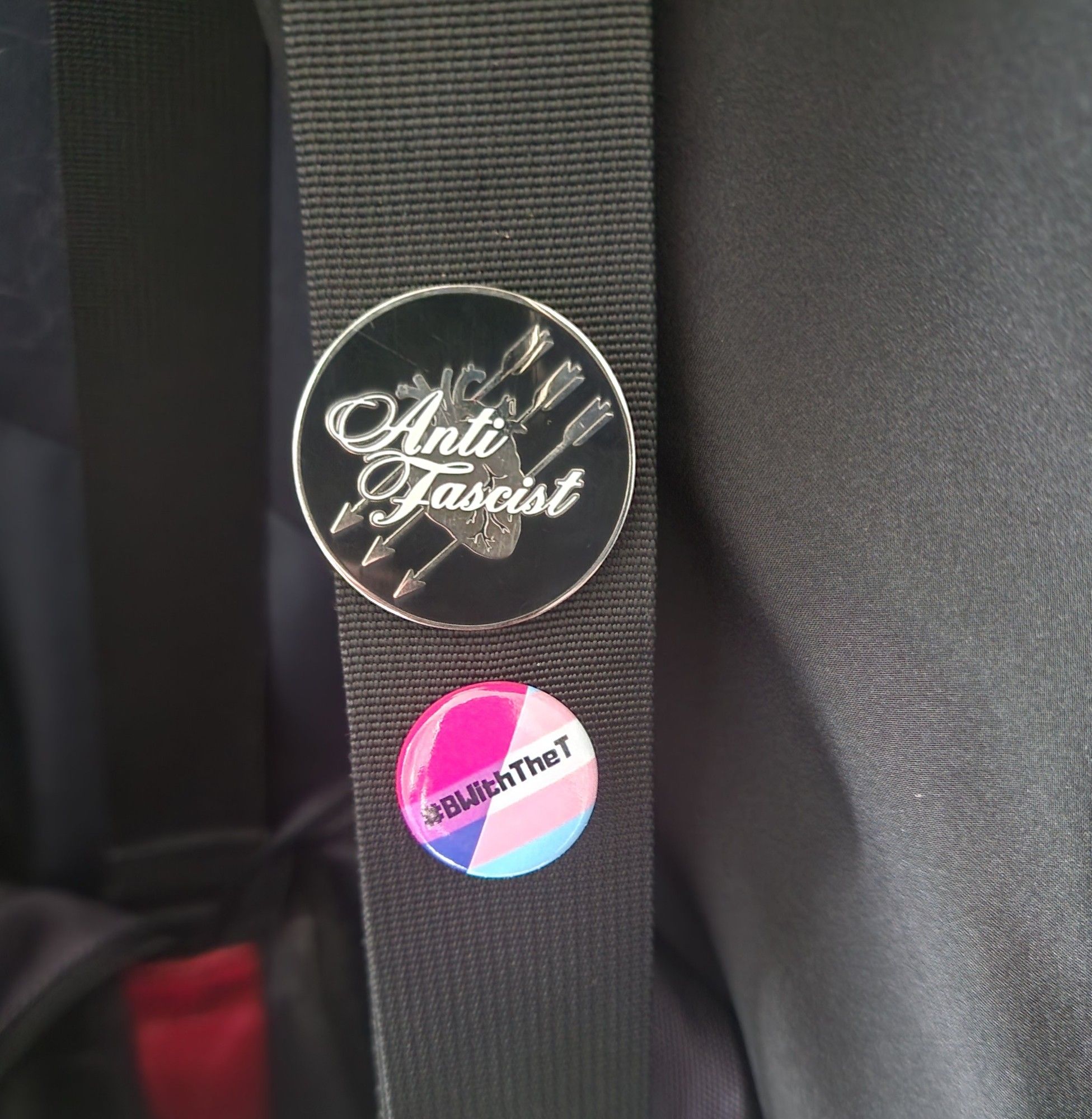 Shoulder strap of my handbag, with an Anti Facist pin from Richard and a #BWithTheT pin from Biscuit