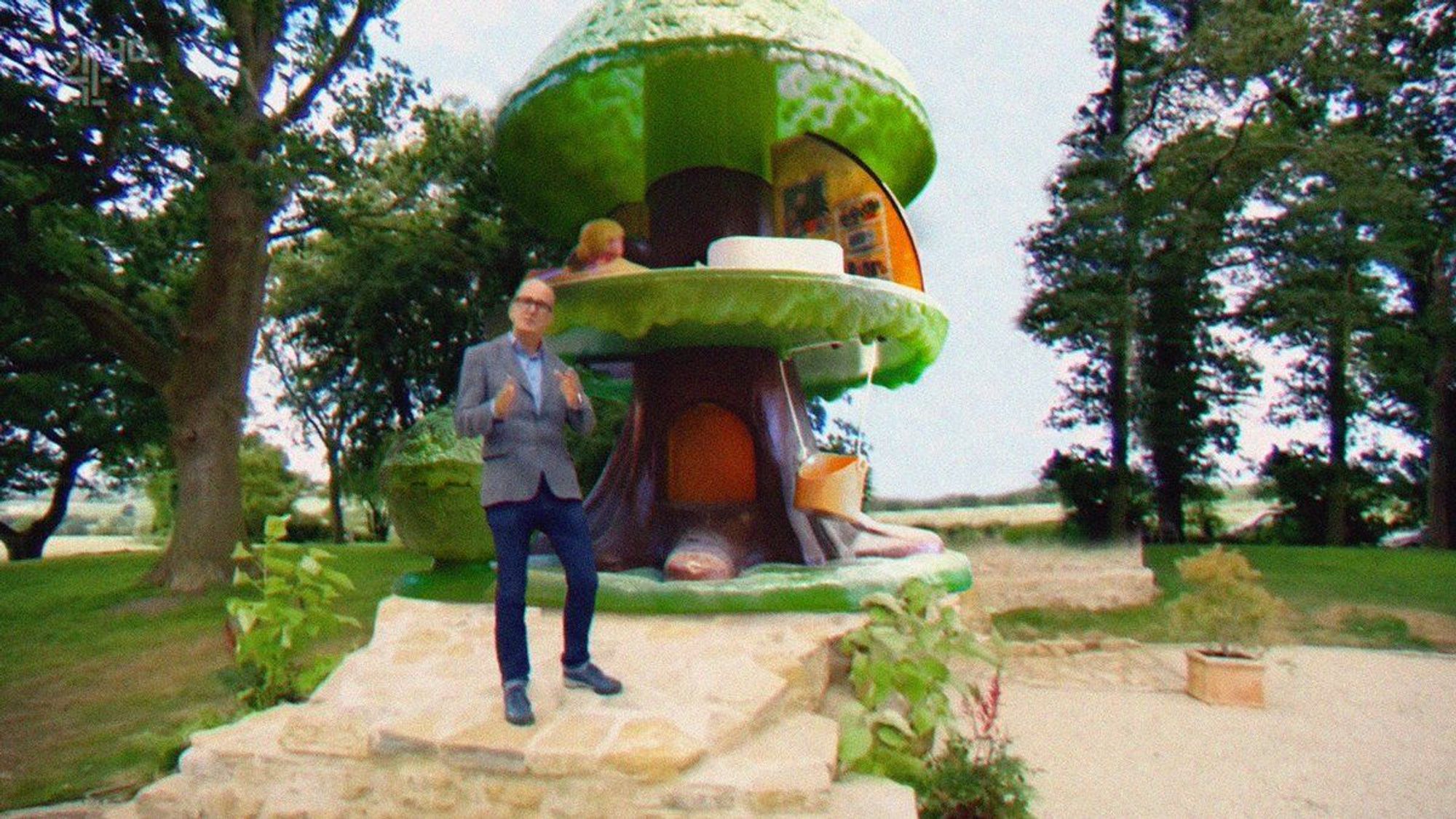 A Photoshop of Kevin McCloud presenting a Grand Designs program with the Palitoy Tree Tots House behind him.