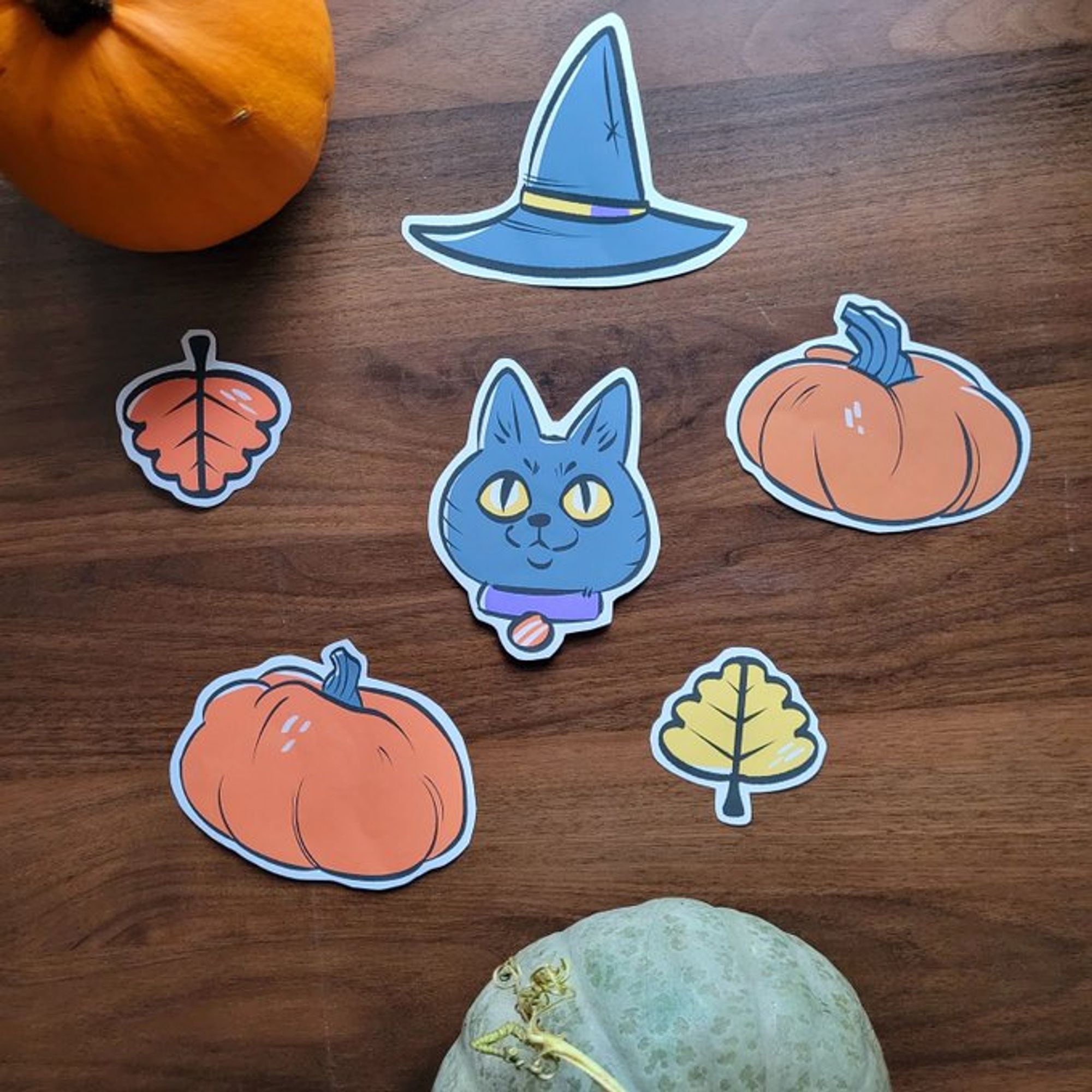 printed out and colored drawings of fall and halloween themed items including leaves, gourds, a cat and a witch hat