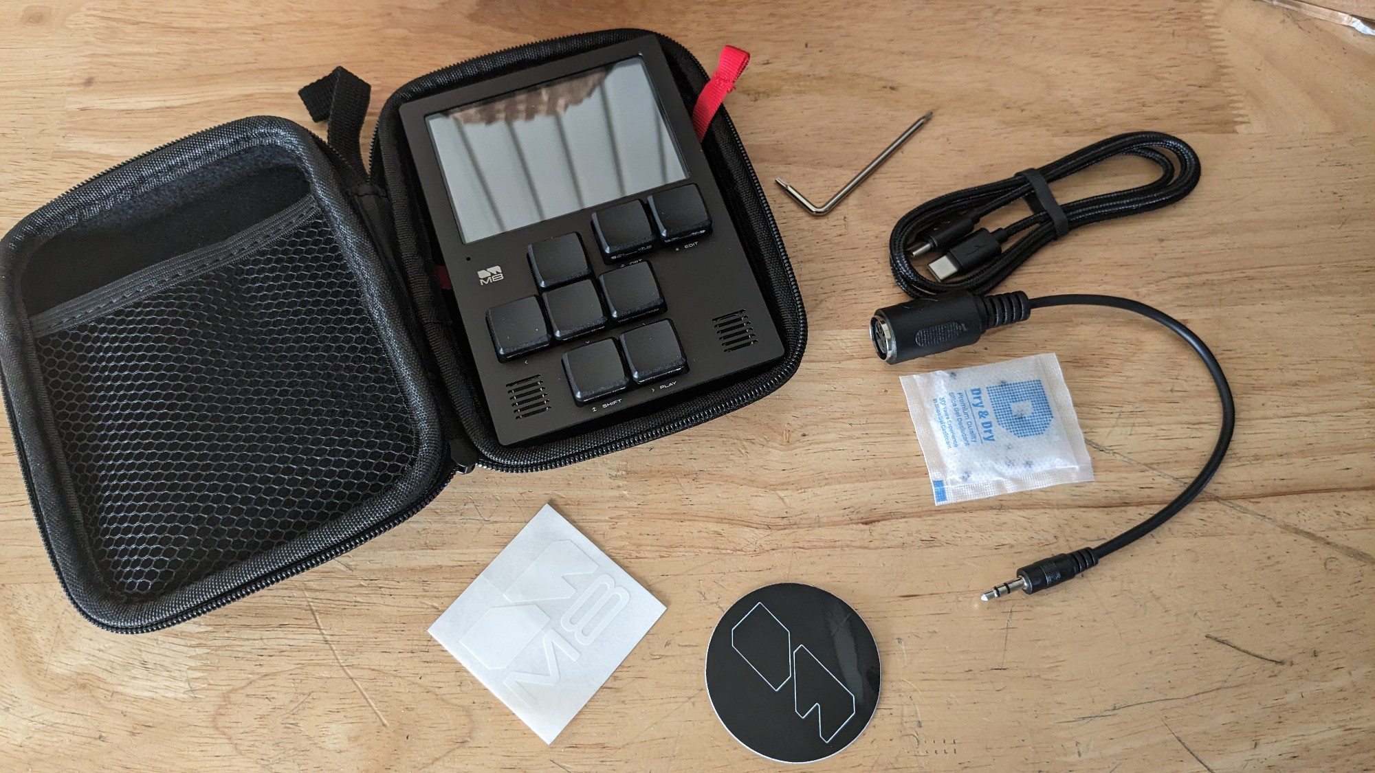 The pouch contains a USB C cable and a small MIDI cable and a couple of stickers 