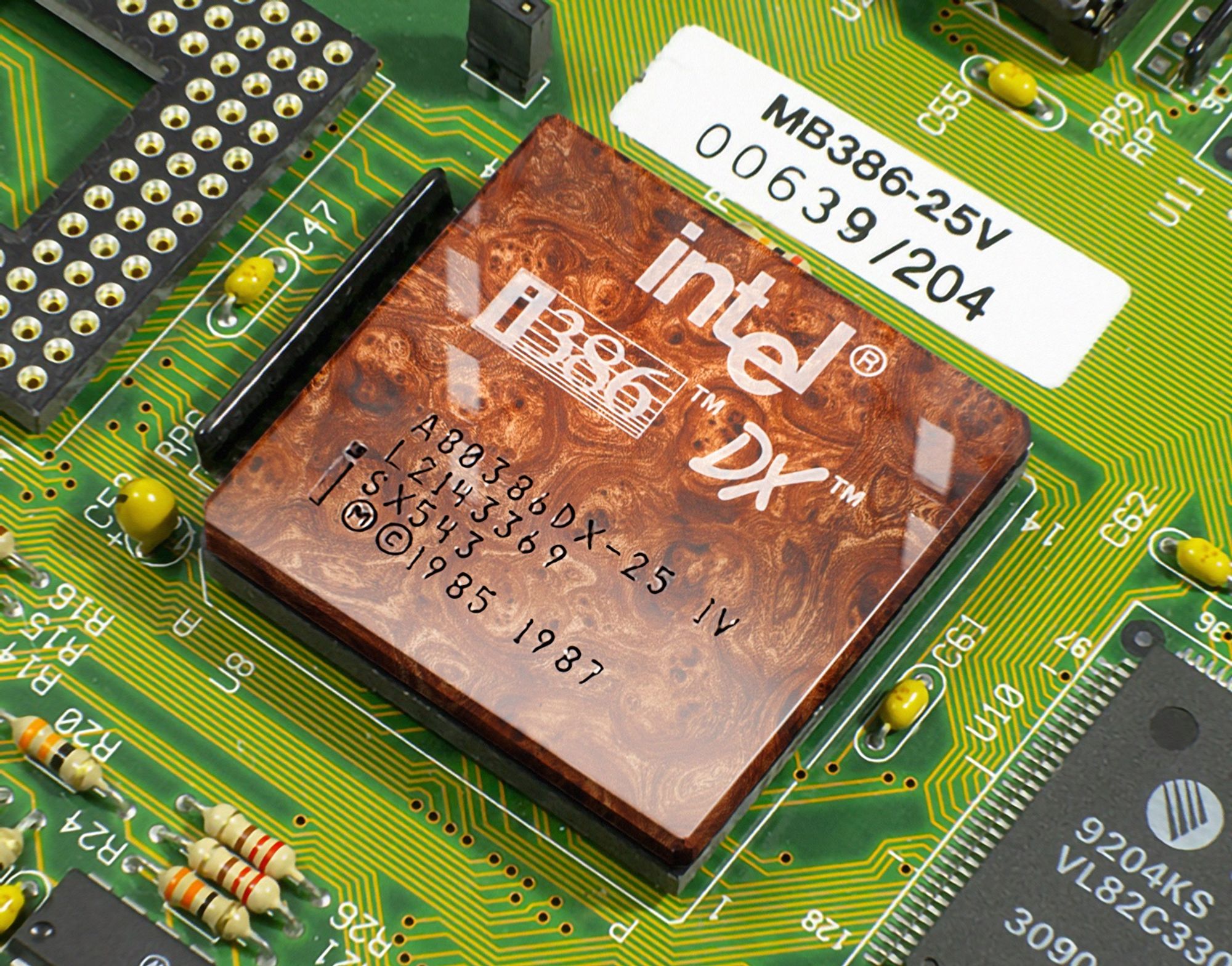 A close-up photo of a 386DX CPU in a socket on a logic board. The CPU's package material is a warm luxurious walnut burl.