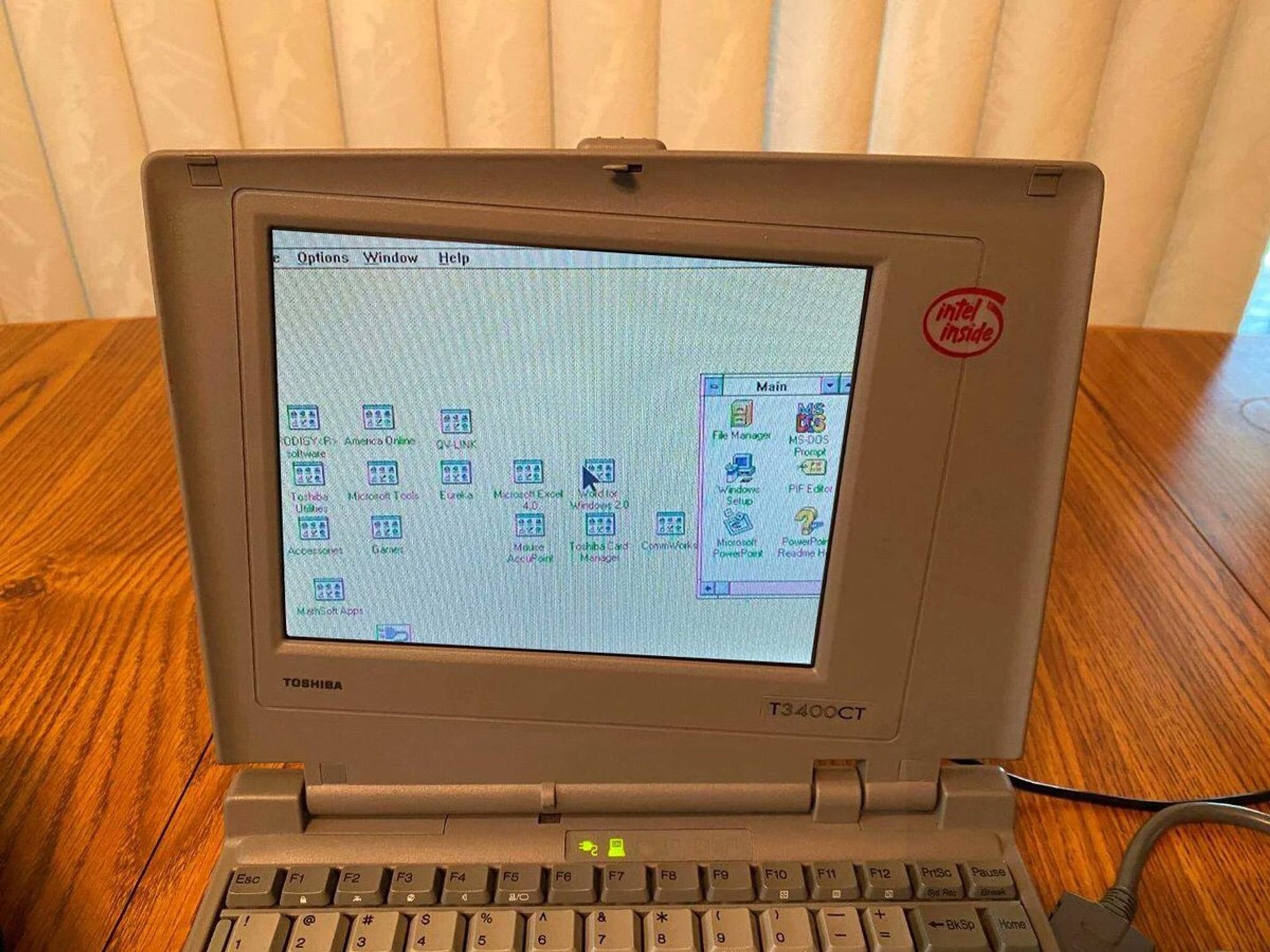 A photo of a Toshiba laptop where the screen appears to be slightly askew with oddly uncomfortable bezels. It’s tilted clockwise but the onscreen image is not.