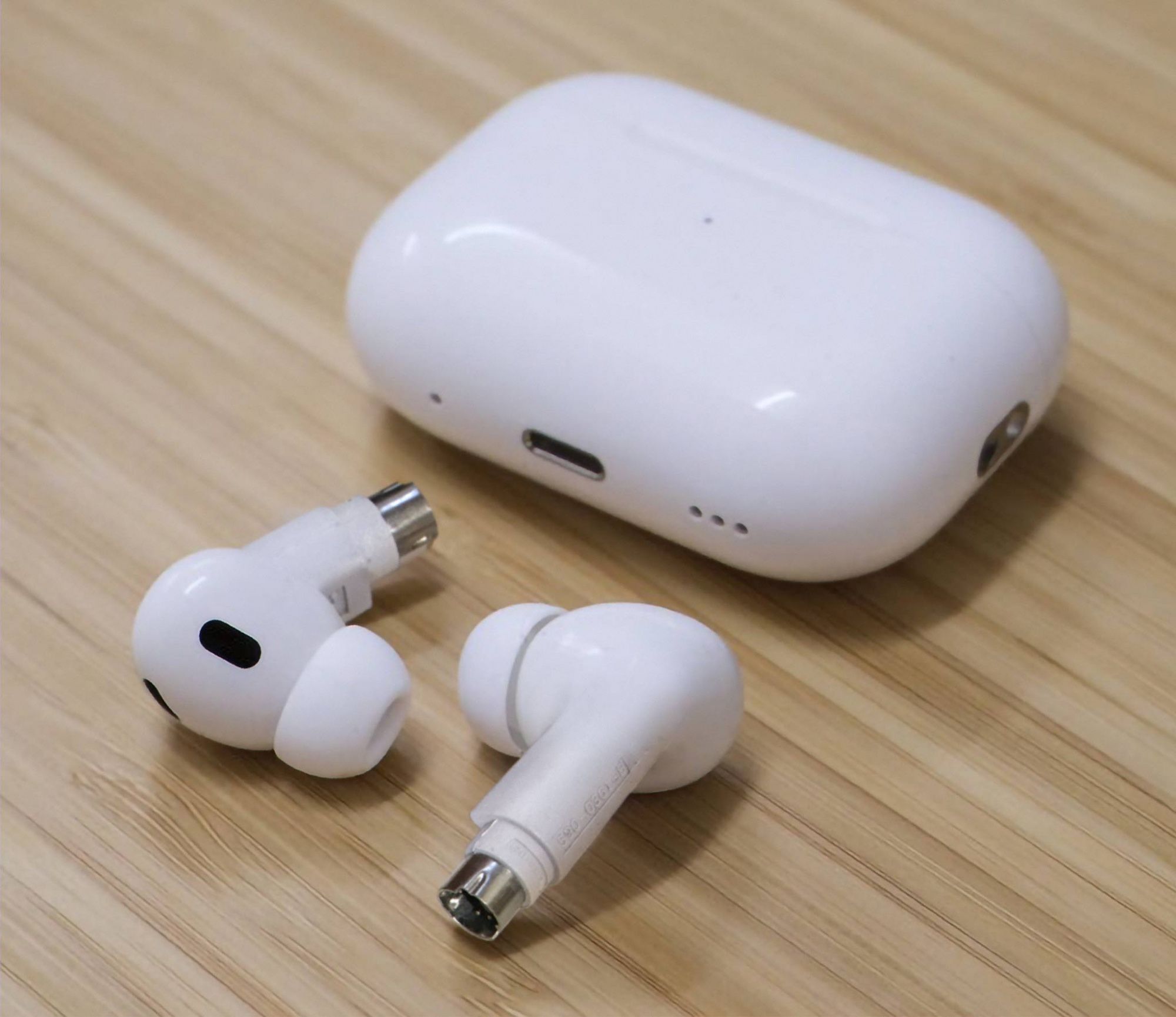 A photo of a pair of Apple ADBPods Pro, white earpods with an ADB connection