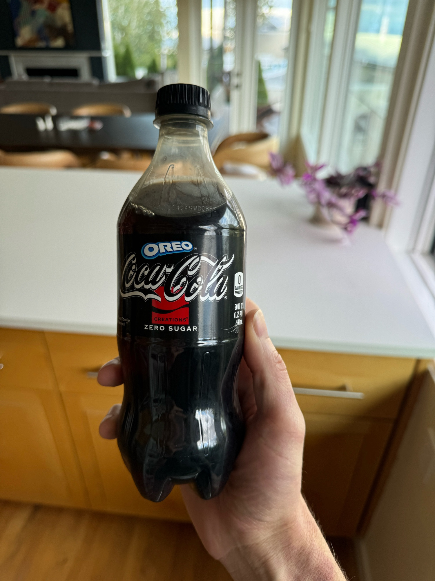 Hand holding a 20oz bottle of Oreo Coca-Cola Zero Sugar collab.