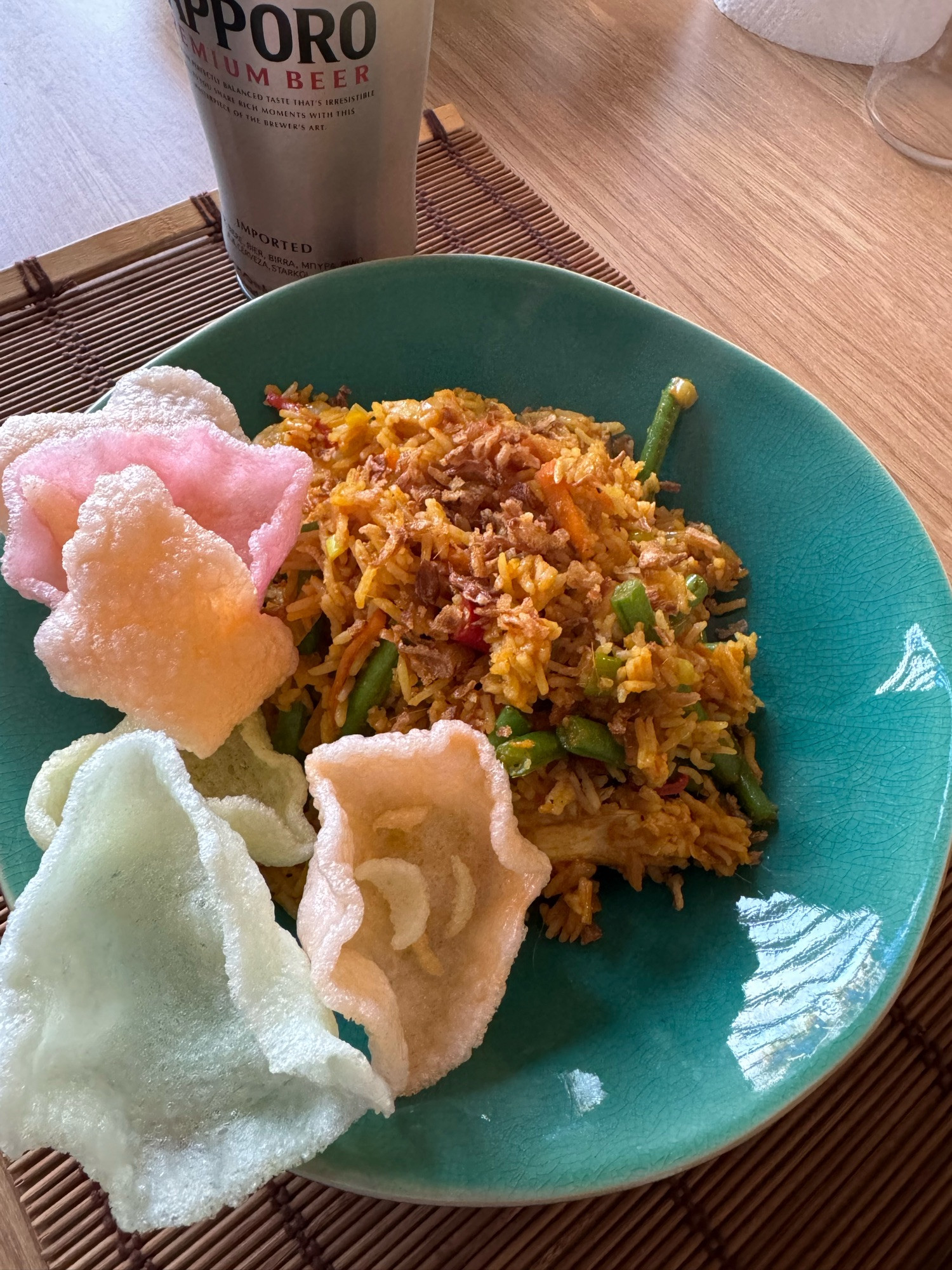 A plate of Nasi Goreng, an Indonesian fried rice dish, served with prawn crackers.