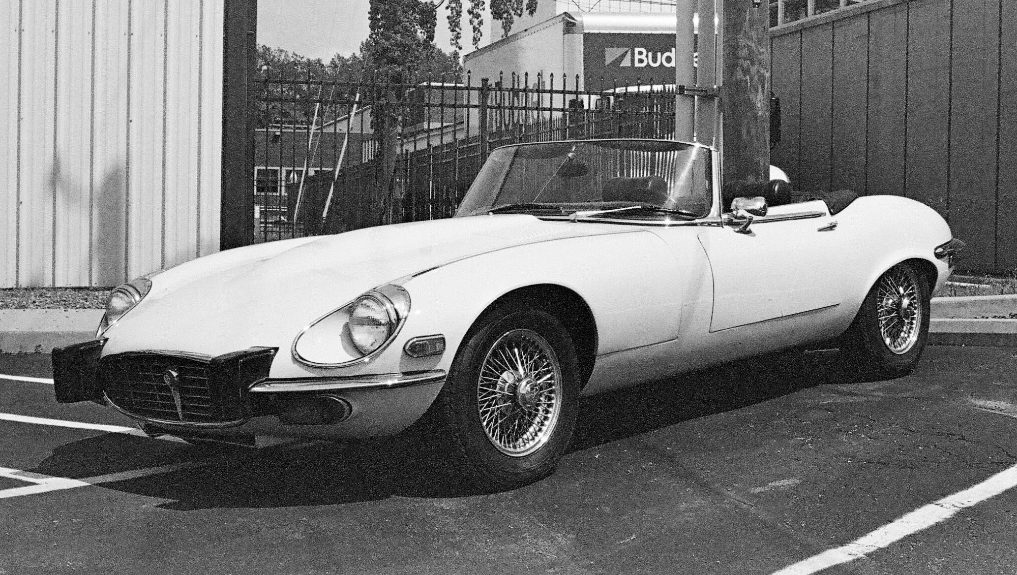 Black and white photo of a 1973 Jaguar E-type with the top lowered.